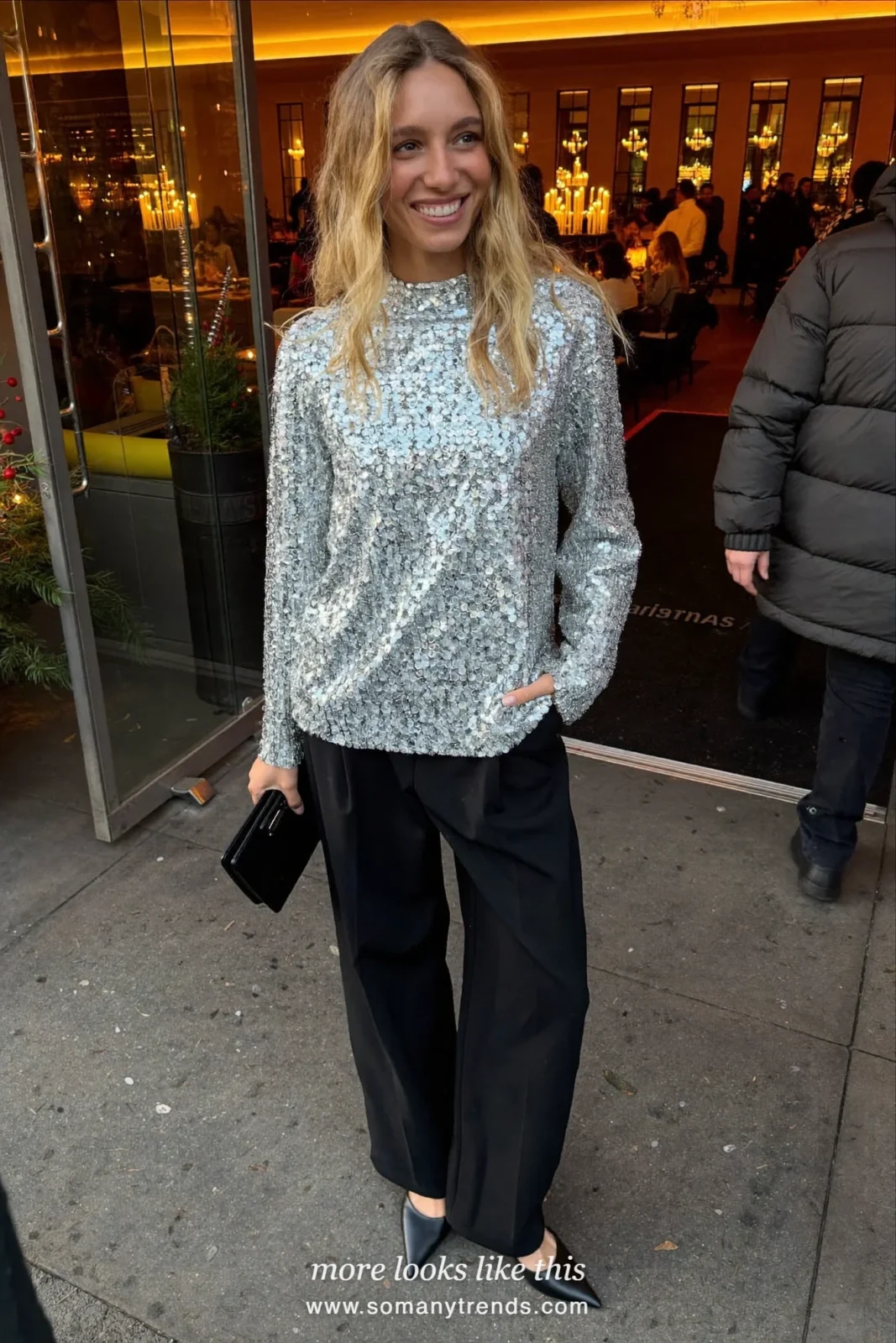 Woman in a silver sequin top, black tailored wide-leg pants and black pumps at a Christmas dinner, outfit 1