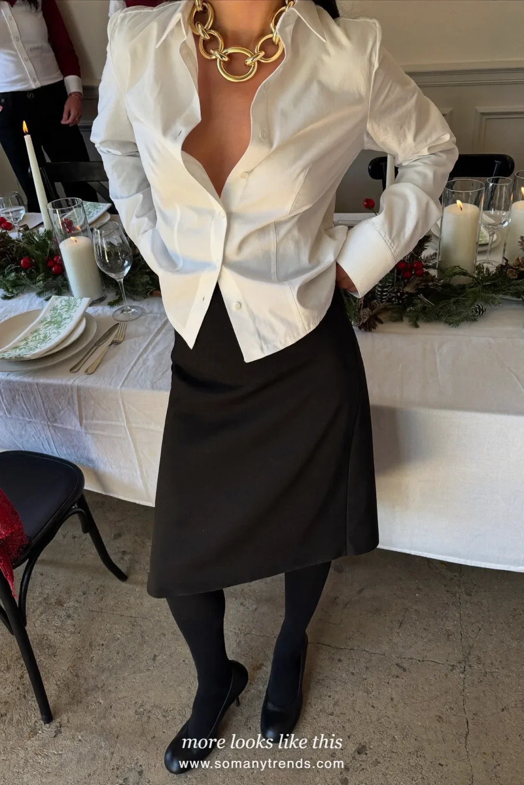 Woman in a white poplin shirt, black A-line midi skirt, statement necklace and black pumps, outfit 6