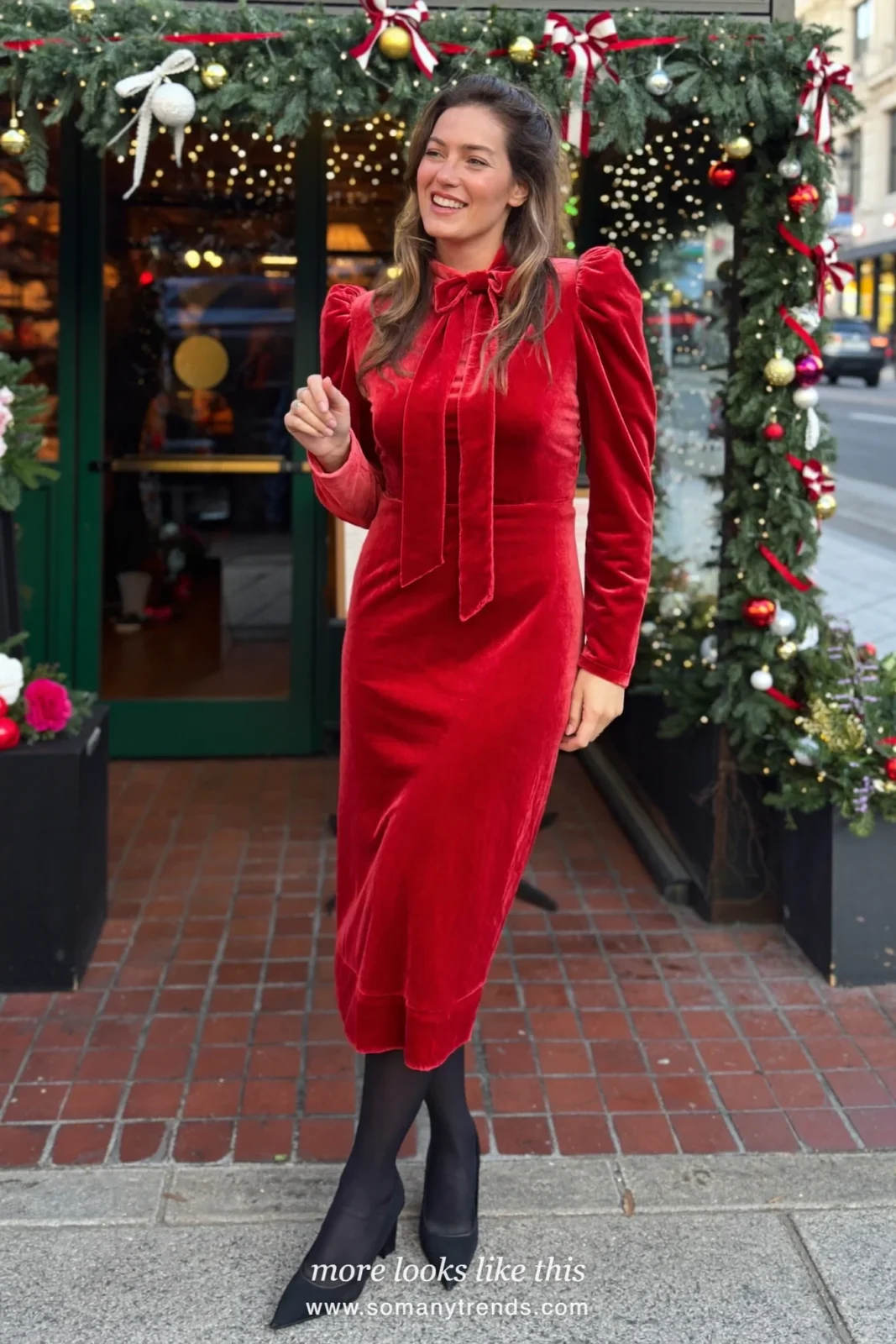 Woman in a cherry red velvet midi dress with a bow neckline and black pumps, outfit 7