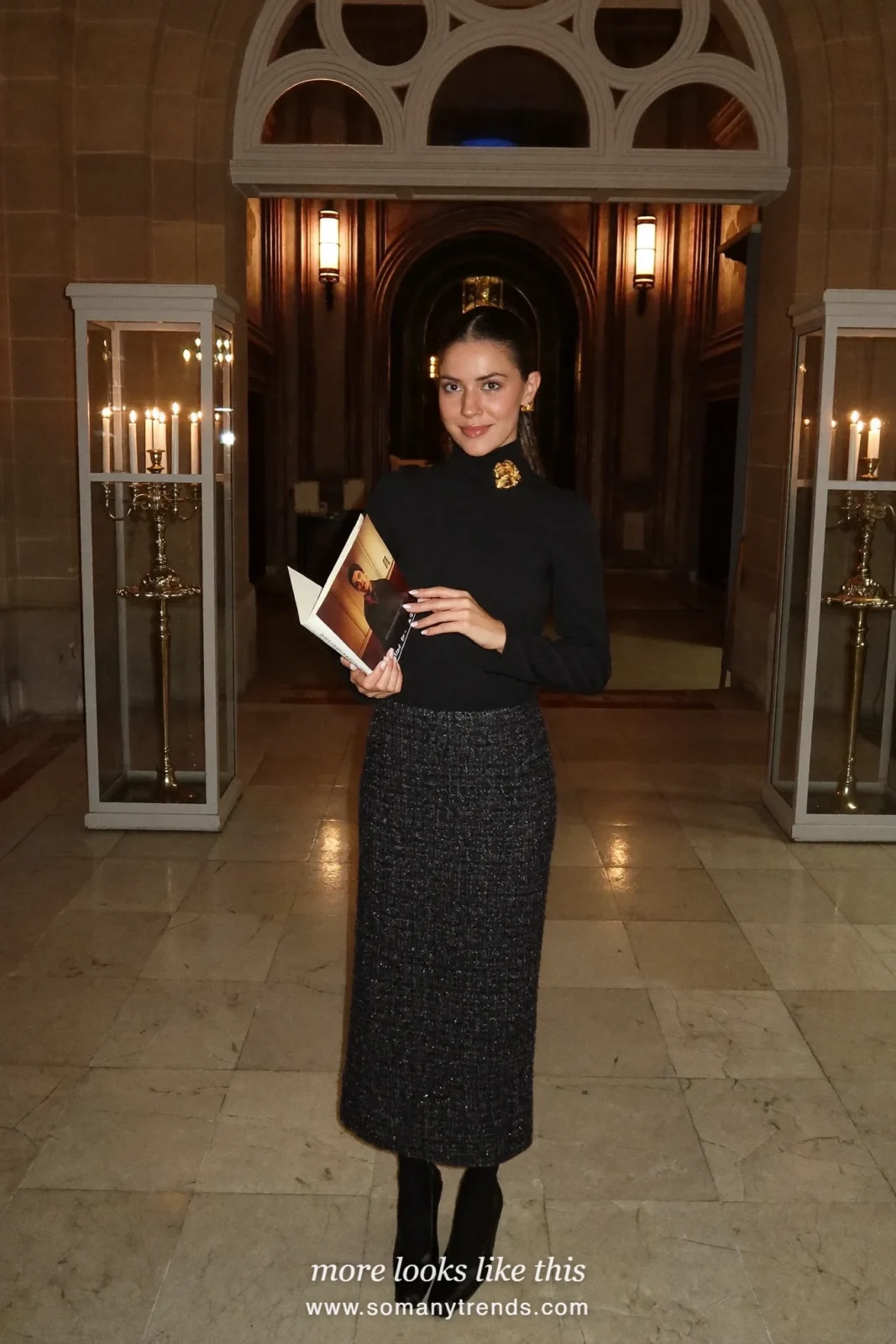 Woman in a charcoal tweed long skirt, black fine turtleneck, gold brooch and black block-heel pumps, church outfit 1