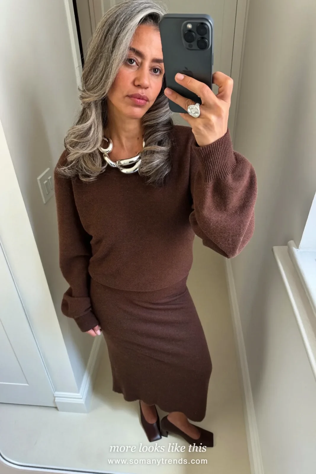 Woman in a chocolate brown knit top and matching midi skirt with a statement necklace and square-toe pumps, outfit 4
