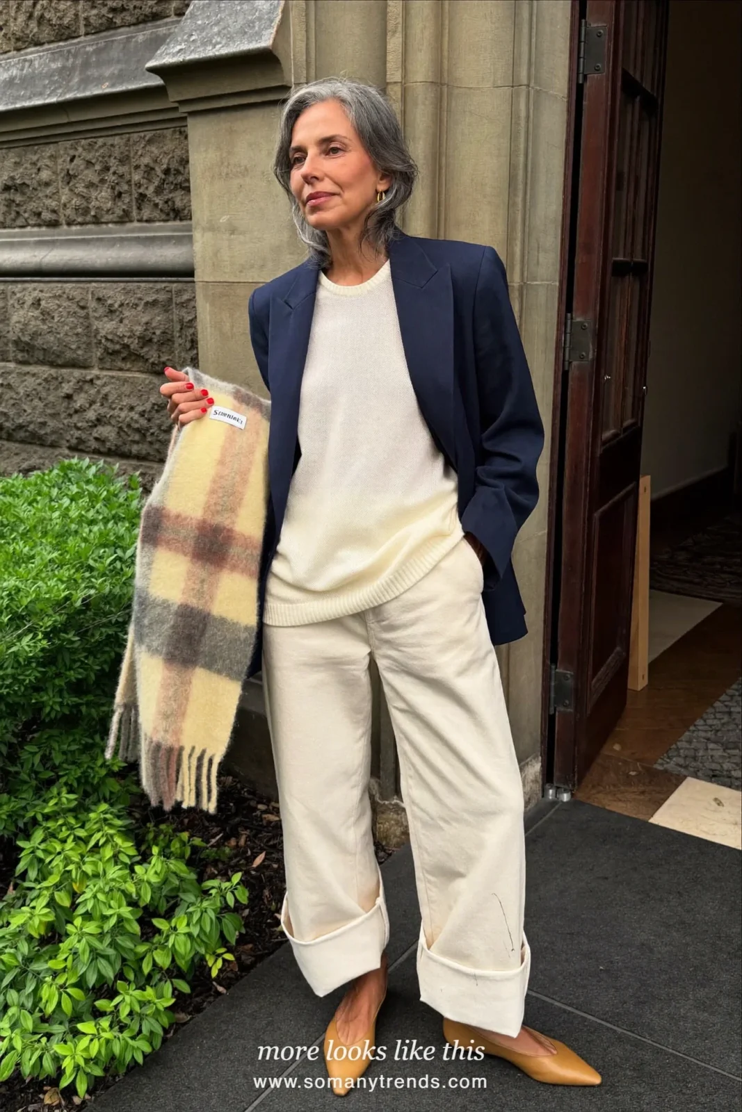 Woman in a navy blazer, ivory knit sweater, cream wide-leg pants and camel pointed flats at a holiday church service, outfit 17
