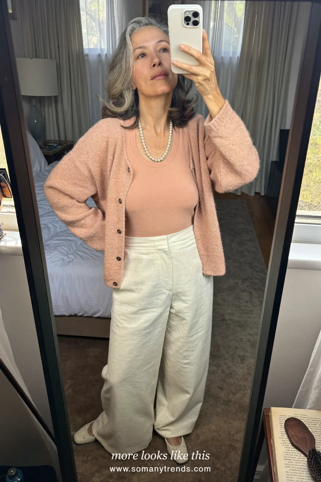 Woman in a blush knit cardigan set, cream pants and ballet flats at a family Christmas brunch, outfit 20