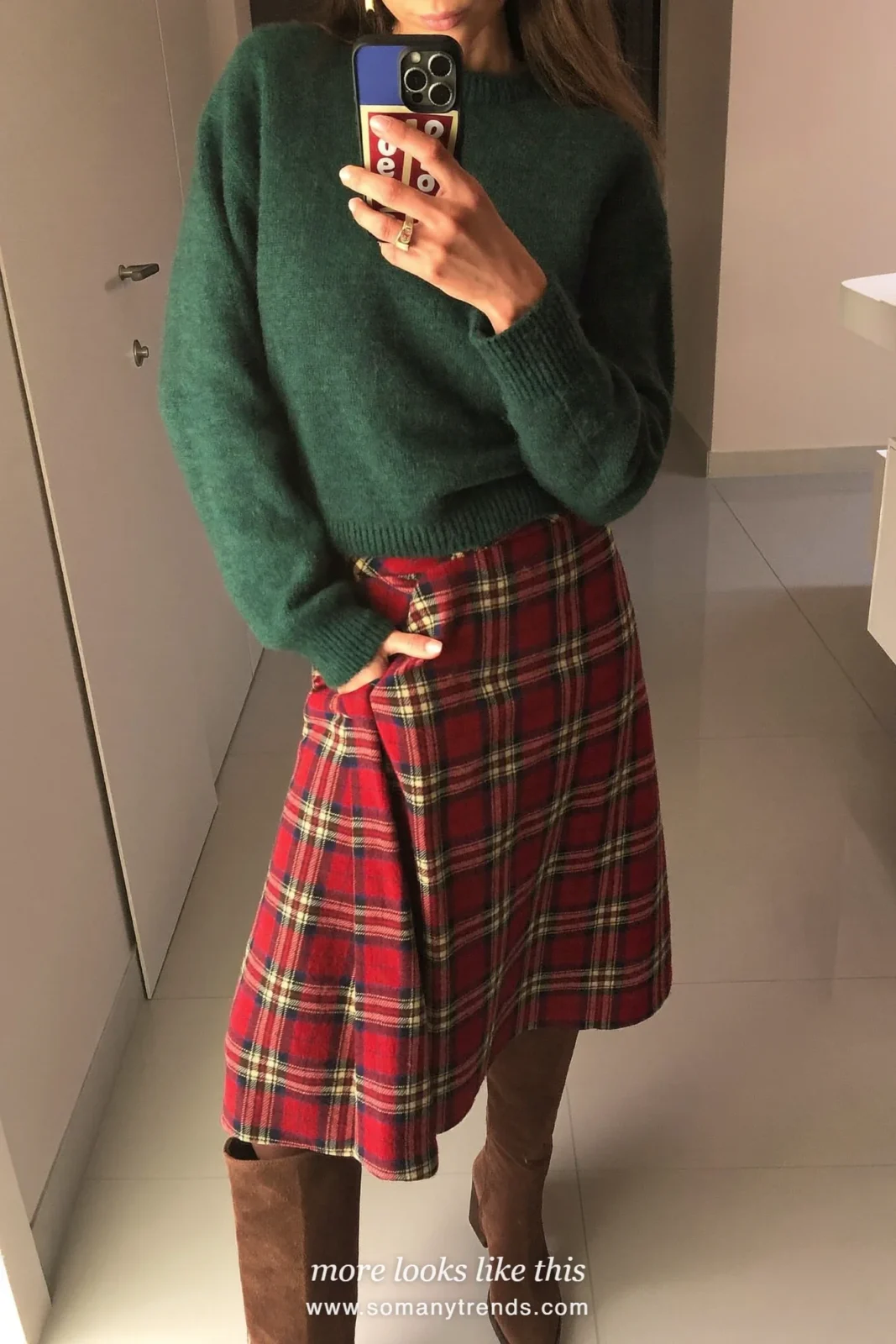 Woman in a forest green sweater, red plaid wrap skirt and brown suede boots at a brunch table, outfit 16