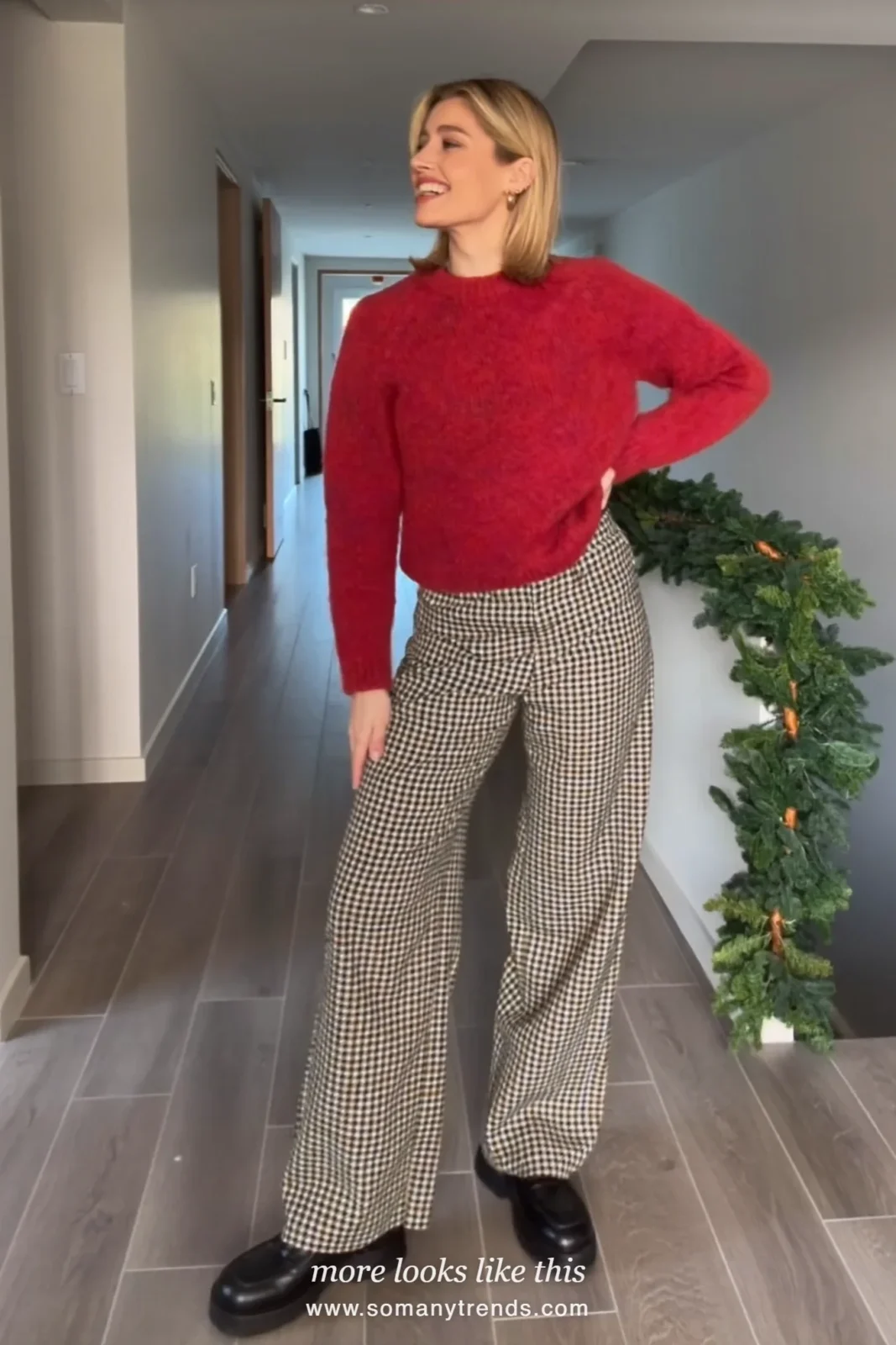 Woman in wide houndstooth pants, cranberry knit and black loafers in a hallway, outfit 18