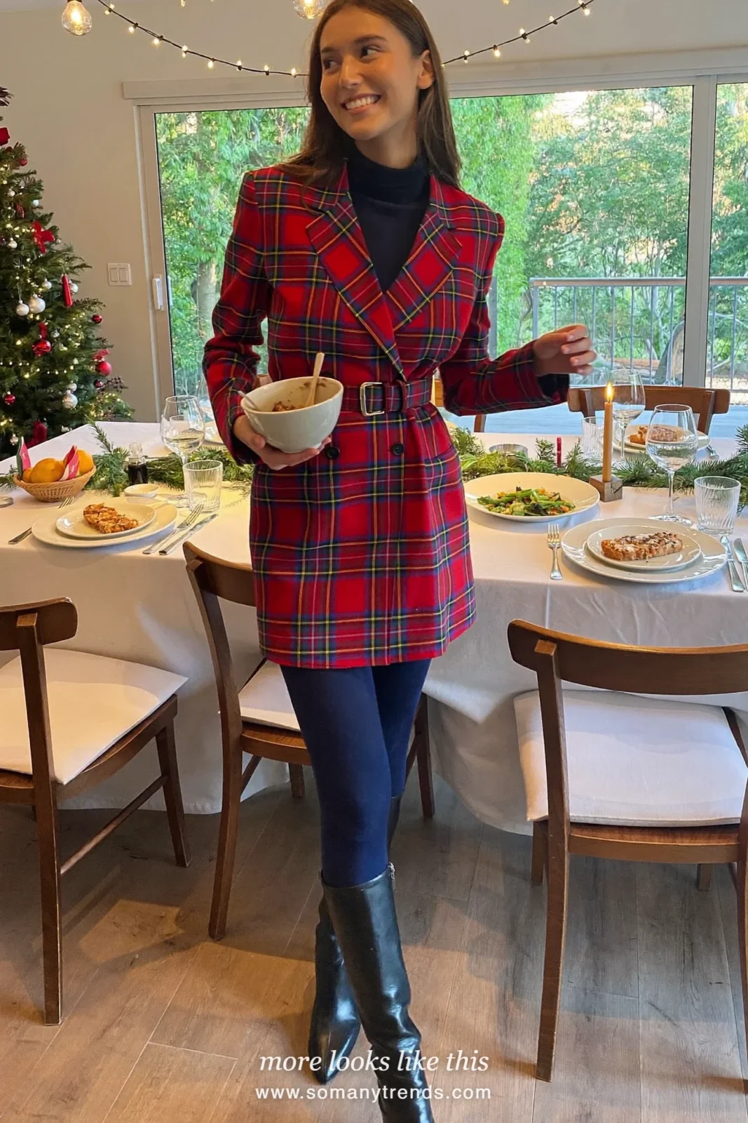 Woman in a red and navy tartan belted blazer dress, black tights and boots in a dining room, outfit 26