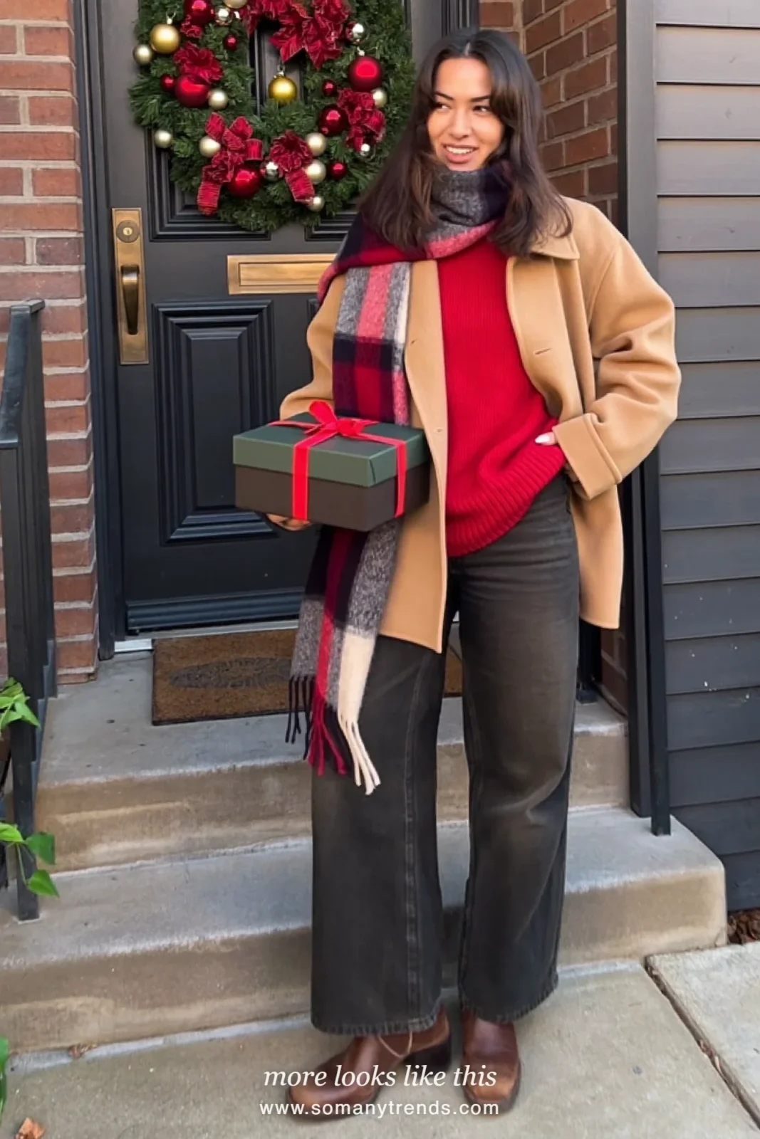 Woman in a camel wool jacket, deep red knit, dark pants, plaid scarf and brown boots at a front door, outfit 27