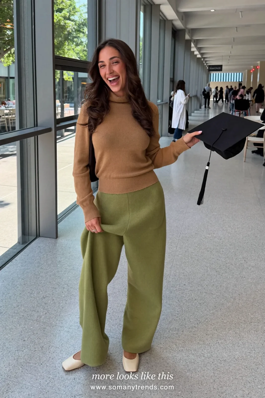 Woman wearing a camel turtleneck sweater, wide-leg pine green pants and cream square-toe flats, winter graduation outfit 5