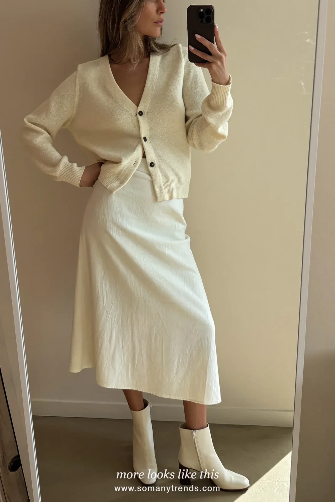 Woman wearing a cream button-front knit cardigan, cream knit midi skirt and cream block-heel ankle boots, winter graduation outfit 16