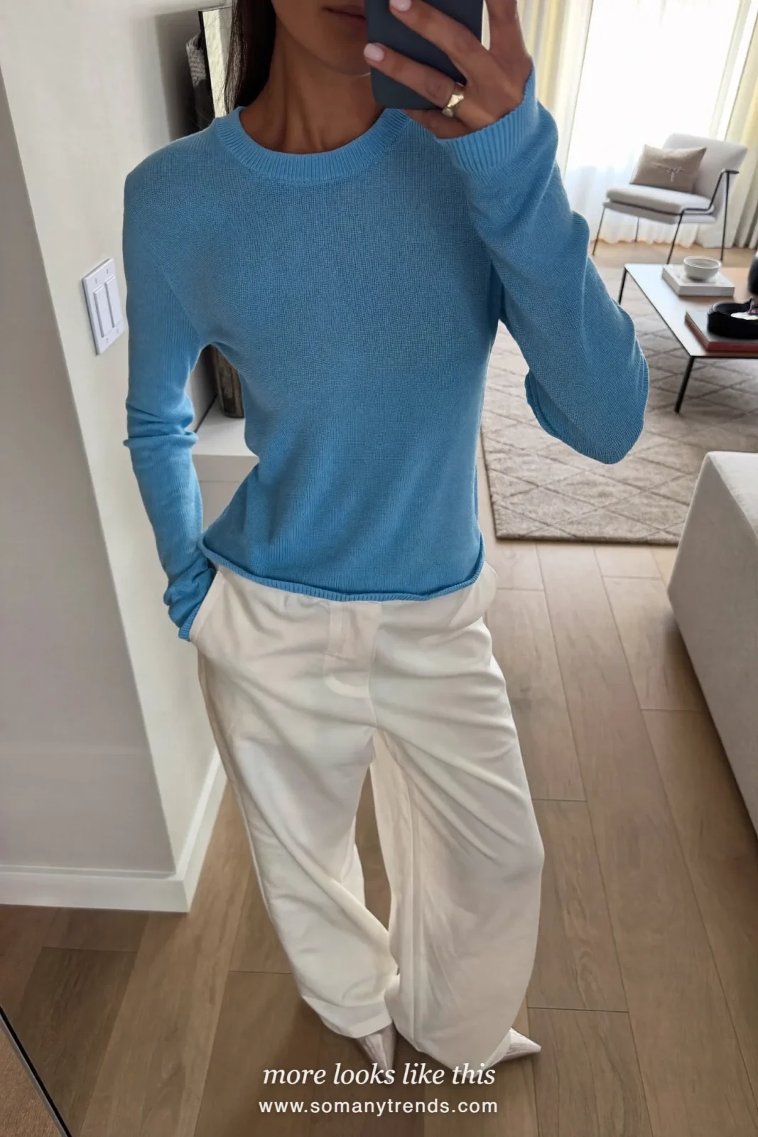 Woman taking a living room mirror selfie in an icy blue knit top, wide white pants and silver flats, spring church outfit 12