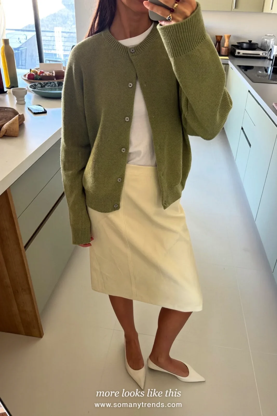 Woman taking a kitchen mirror selfie in a sage cardigan, white tee, long cream skirt and cream flats, spring church outfit 28