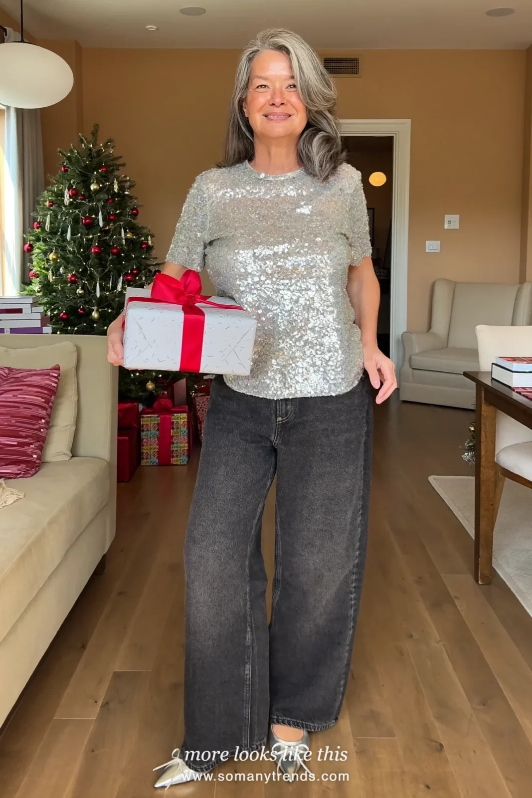 Woman in a silver sequin tee, dark relaxed straight-leg jeans and pointed silver flats at a Christmas open house, outfit 1