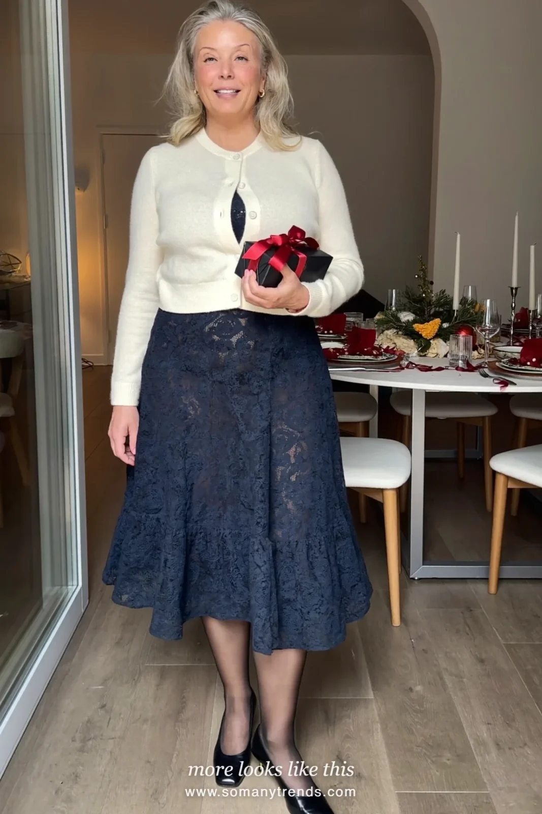 Woman in a navy lace long-sleeve midi dress, cream cardigan, sheer black tights and low pumps at a family Christmas dinner, outfit 11