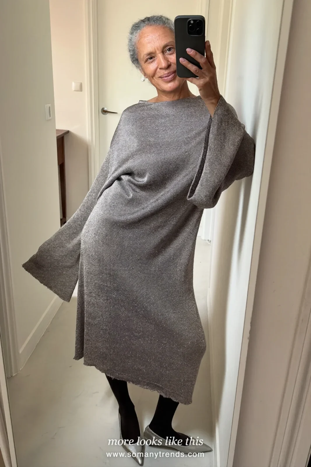 Woman in a loose silver-gray knit midi dress, sheer black tights and silver pointed flats at a Christmas party, outfit 28