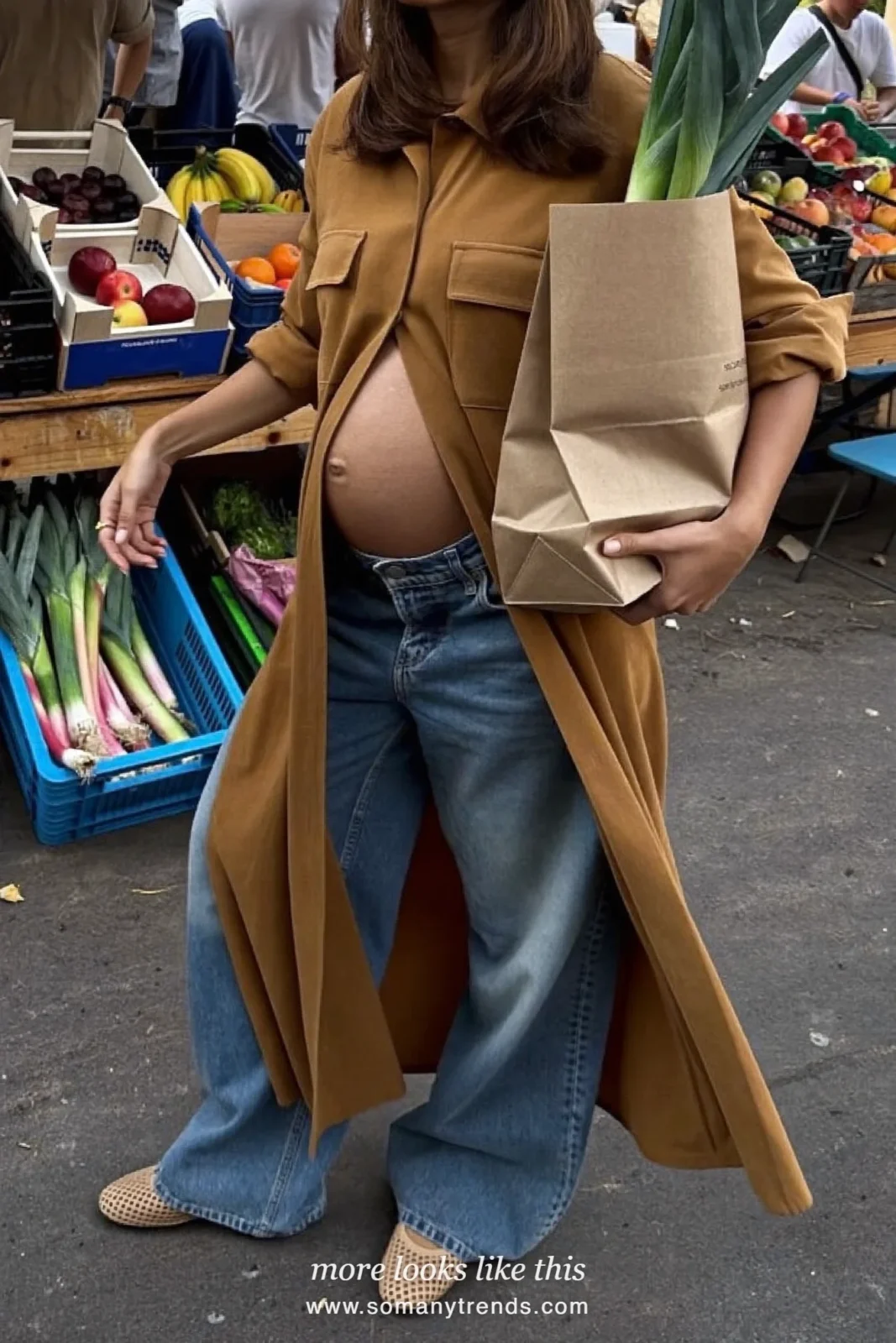 Woman with a baby bump in a long caramel shirt, faded wide-leg maternity jeans and perforated ballet flats, outfit 25