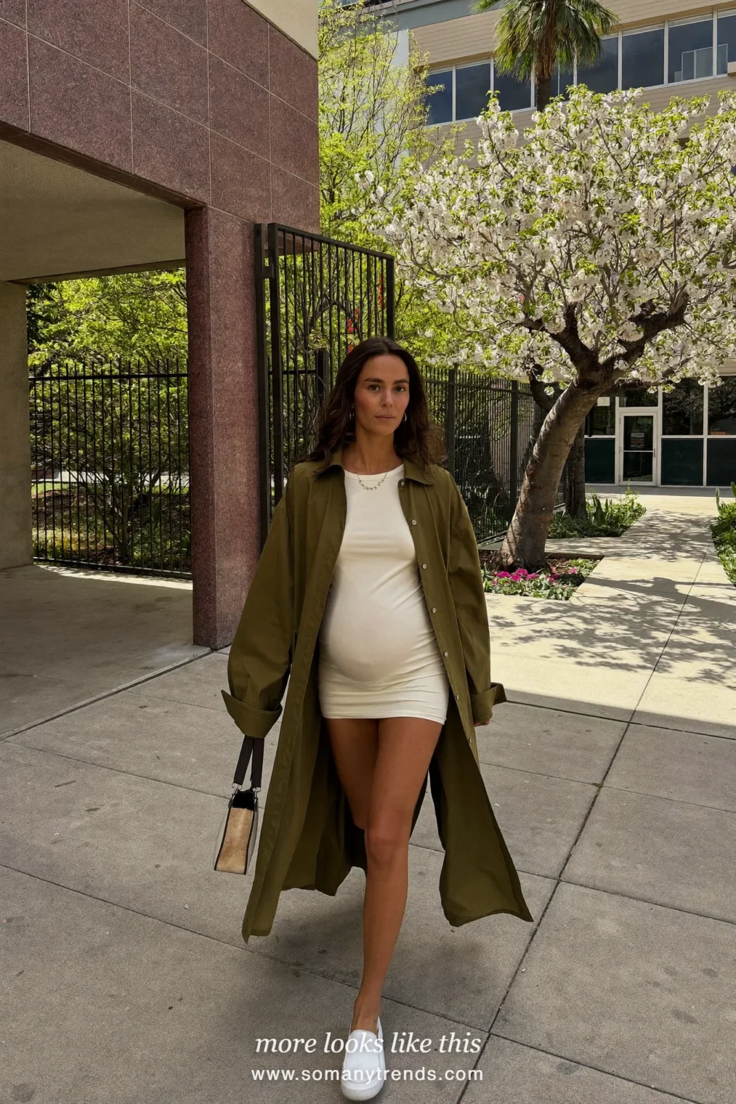 Woman with a baby bump in an olive twill shirt dress worn open over an ivory tee and slip-on sneakers, outfit 26