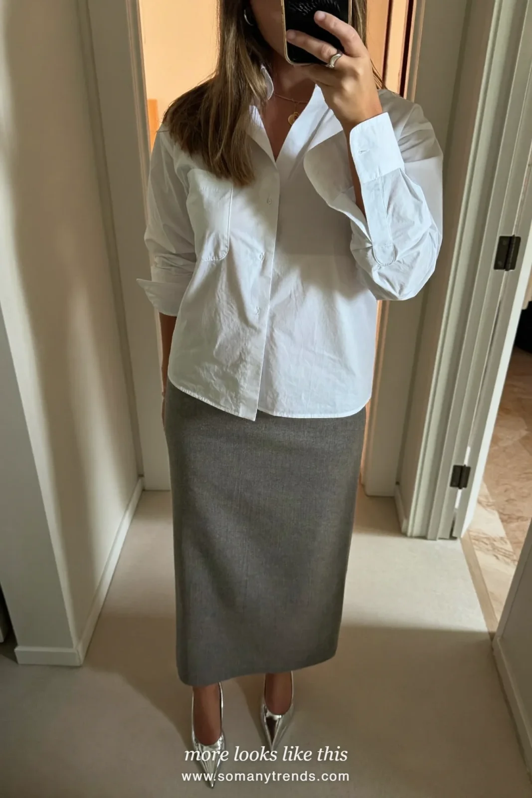 Woman taking a hallway mirror selfie in a white shirt, long gray column skirt and silver pumps, spring church outfit 4