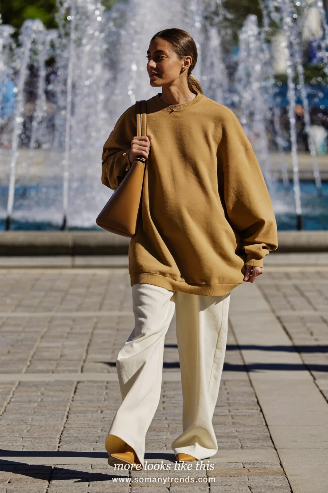 Woman with a baby bump in a caramel tunic top, ivory wide-leg maternity pants and pointed flats, outfit 7