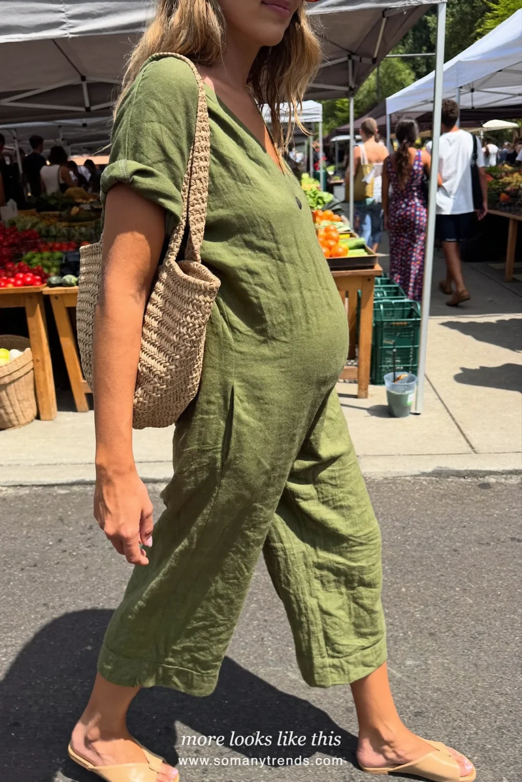 Woman with a baby bump in an olive linen maternity jumpsuit and flat sandals, outfit 11