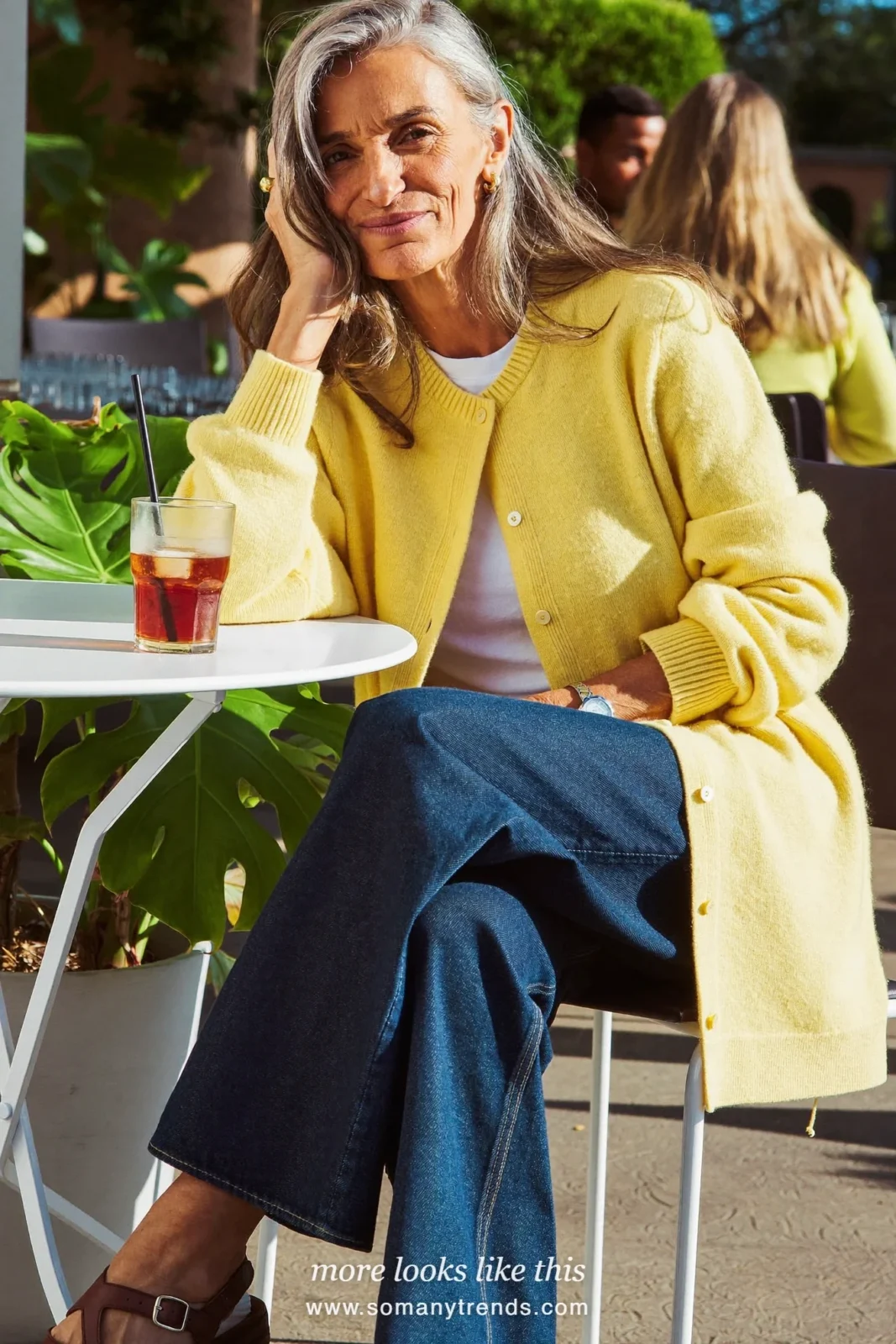 Woman in her forties wearing butter yellow cardigan, white tee, wide-leg indigo jeans and brown leather sandals, outfit 10