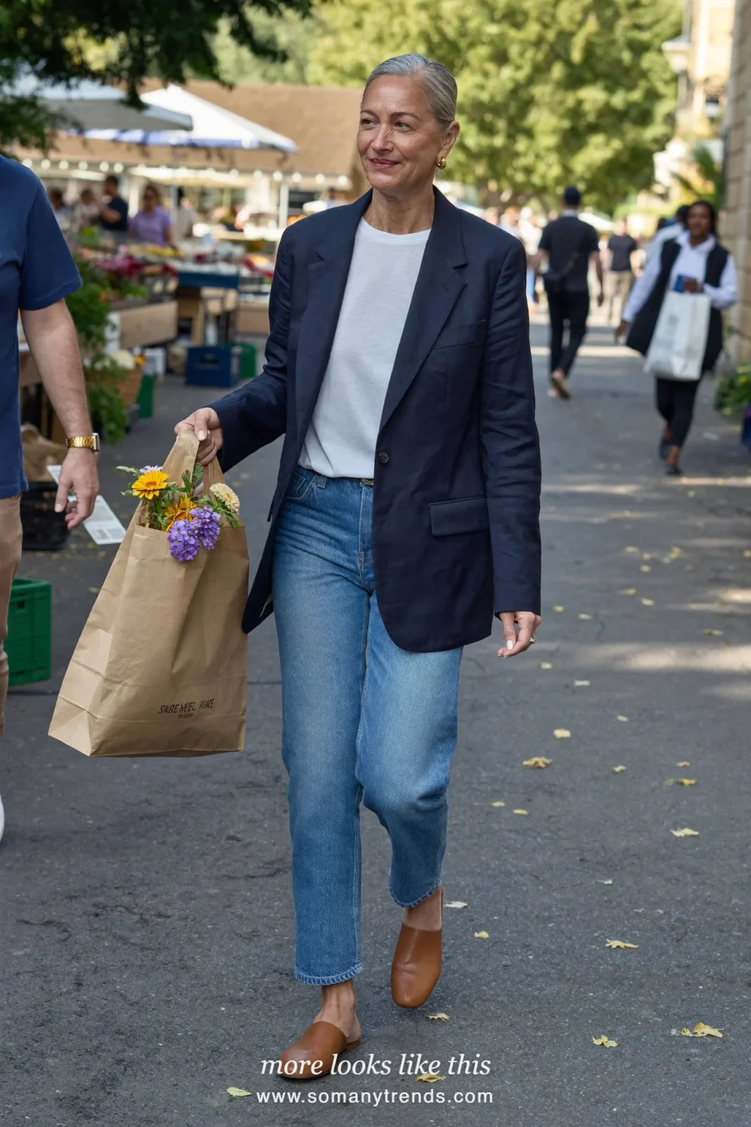 Woman in her forties wearing navy boxy blazer, white tee, mid-blue barrel jeans and tan flat mules, outfit 13