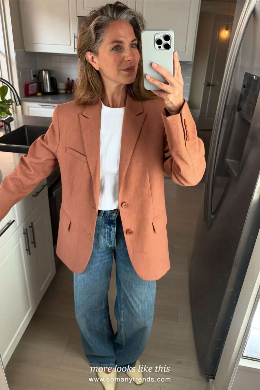 Woman in her forties wearing terracotta relaxed blazer, white tee, straight mid-blue jeans and cream pointed flats, outfit 24