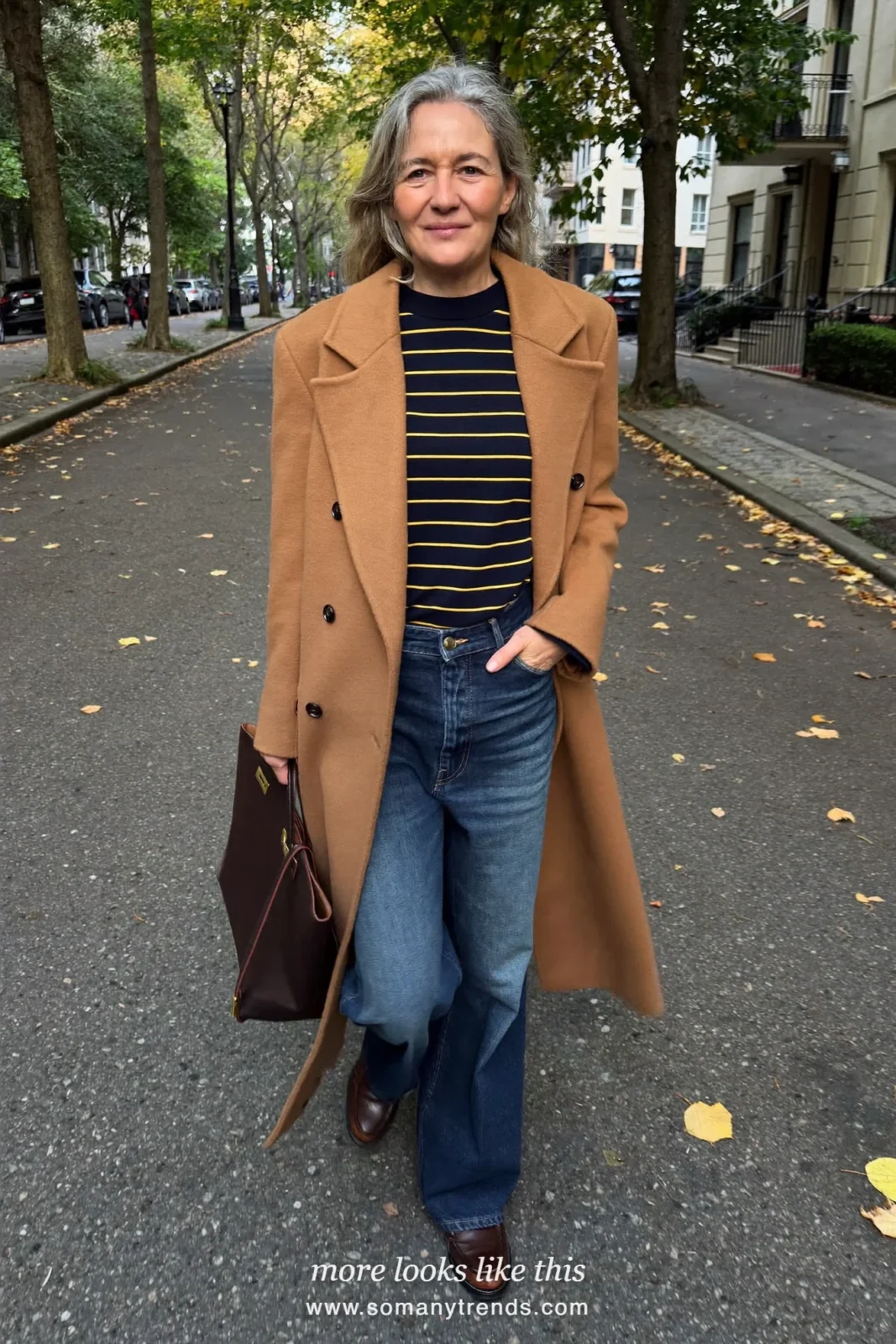 Woman in her forties wearing camel light coat, navy striped knit, wide-leg indigo jeans and brown loafers, outfit 26
