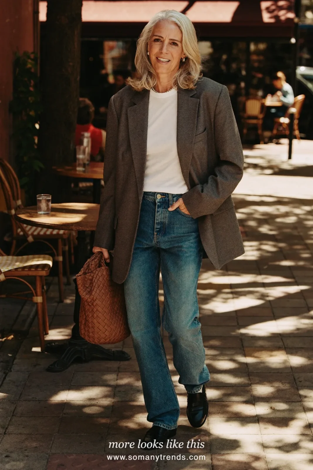 Woman over 50 in a relaxed gray blazer, white tee, barrel-leg blue jeans and black loafers, outfit 5