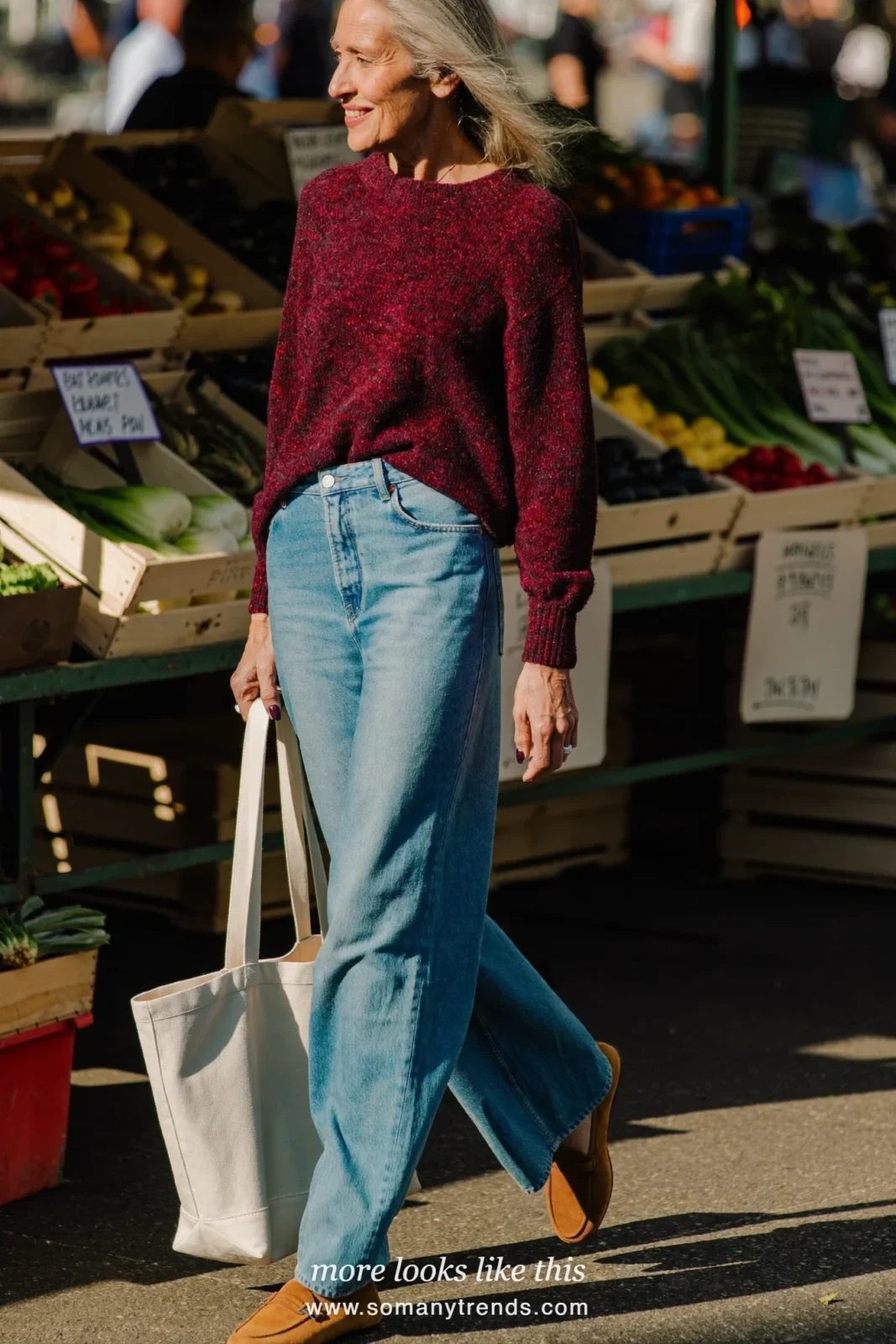 Woman over 50 in a burgundy lightweight sweater, light blue straight jeans and tan suede loafers, outfit 6