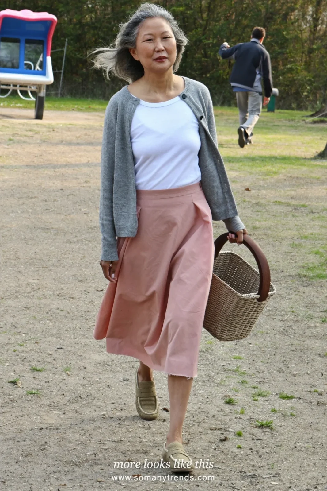 Woman over 50 in a dusty pink poplin A-line midi skirt, gray cardigan and tan loafers, outfit 11