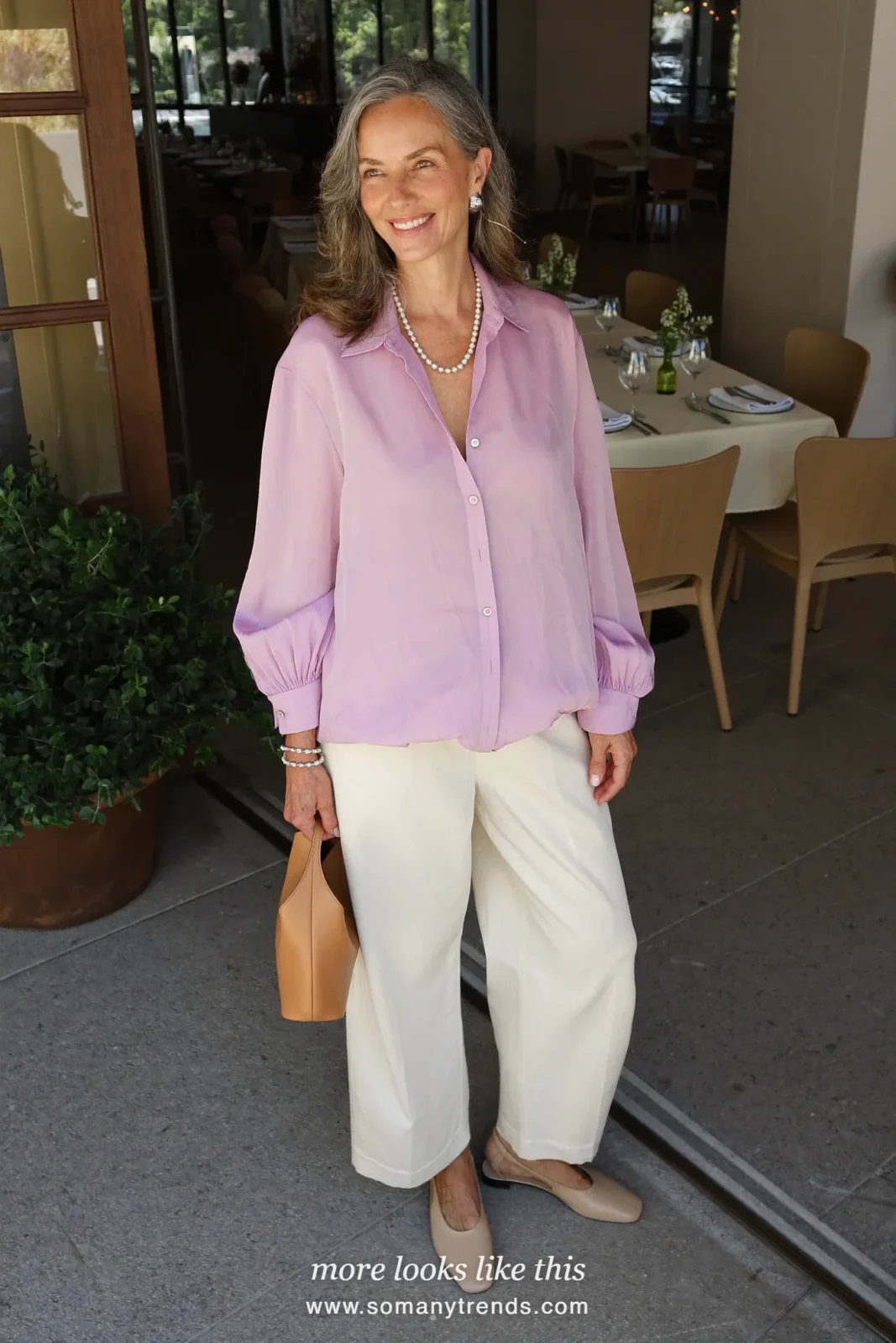 Woman over 50 in a soft pink collared blouse, wide cream pants and nude slingback flats, outfit 17