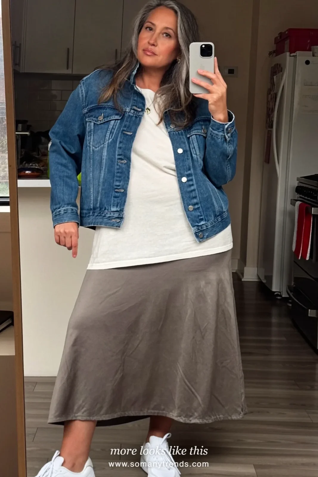 Woman over 50 in a hip-length denim jacket, white tee, long gray skirt and white sneakers, outfit 20