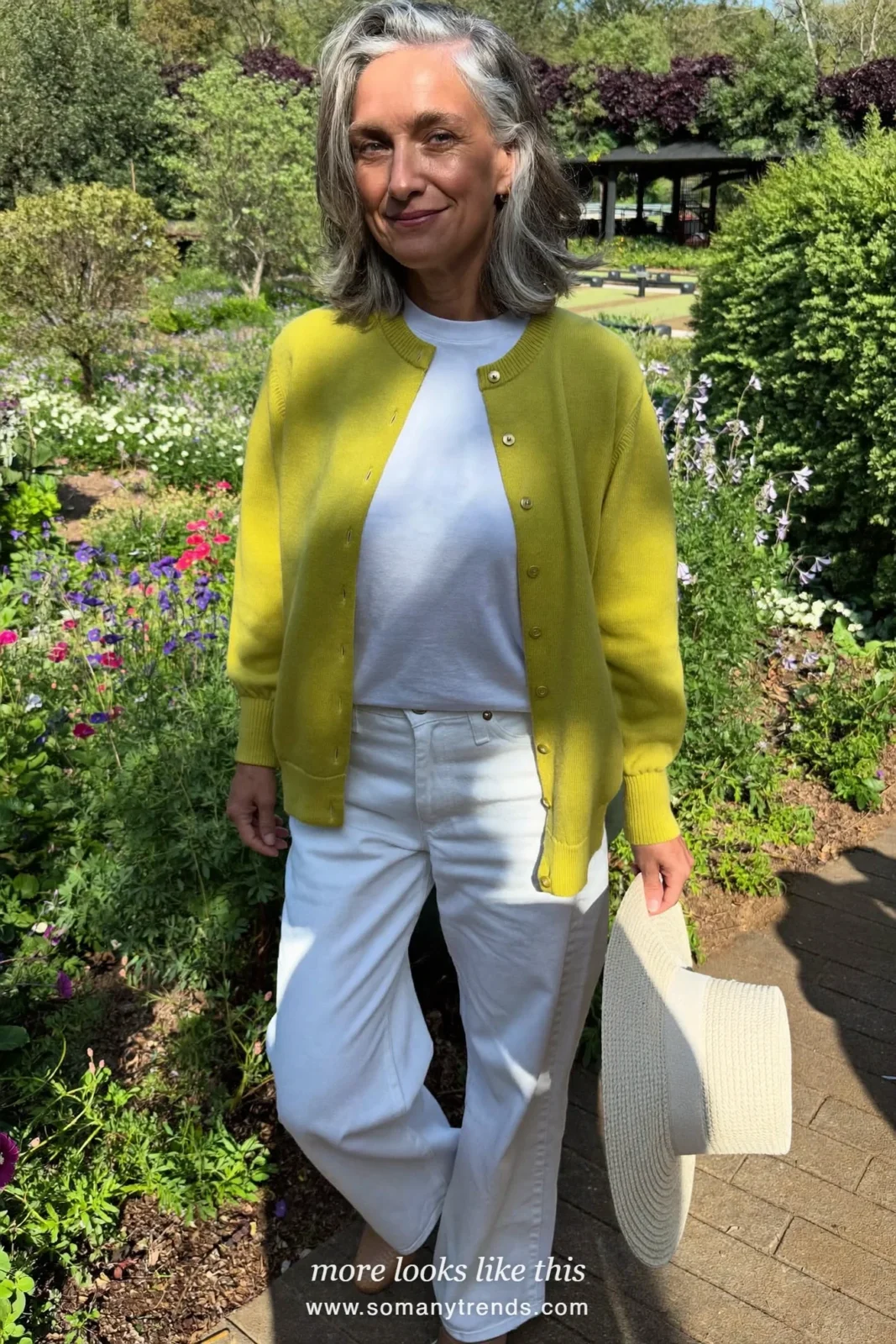 Woman over 50 in a chartreuse fine-knit cardigan, white straight jeans and tan flats, outfit 25
