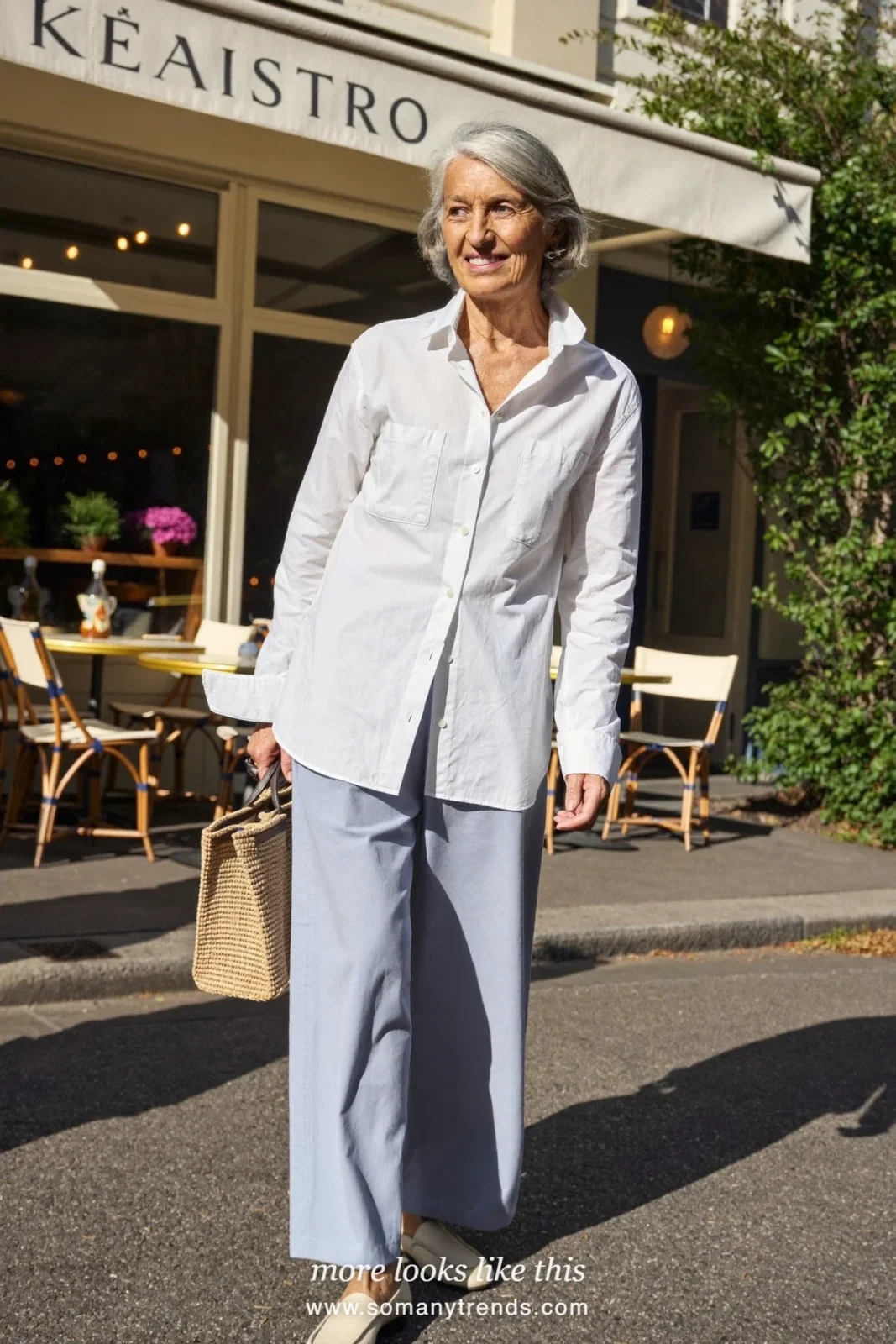 Woman in her seventies in a crisp white shirt, relaxed gray-blue pants and soft loafers, look 7