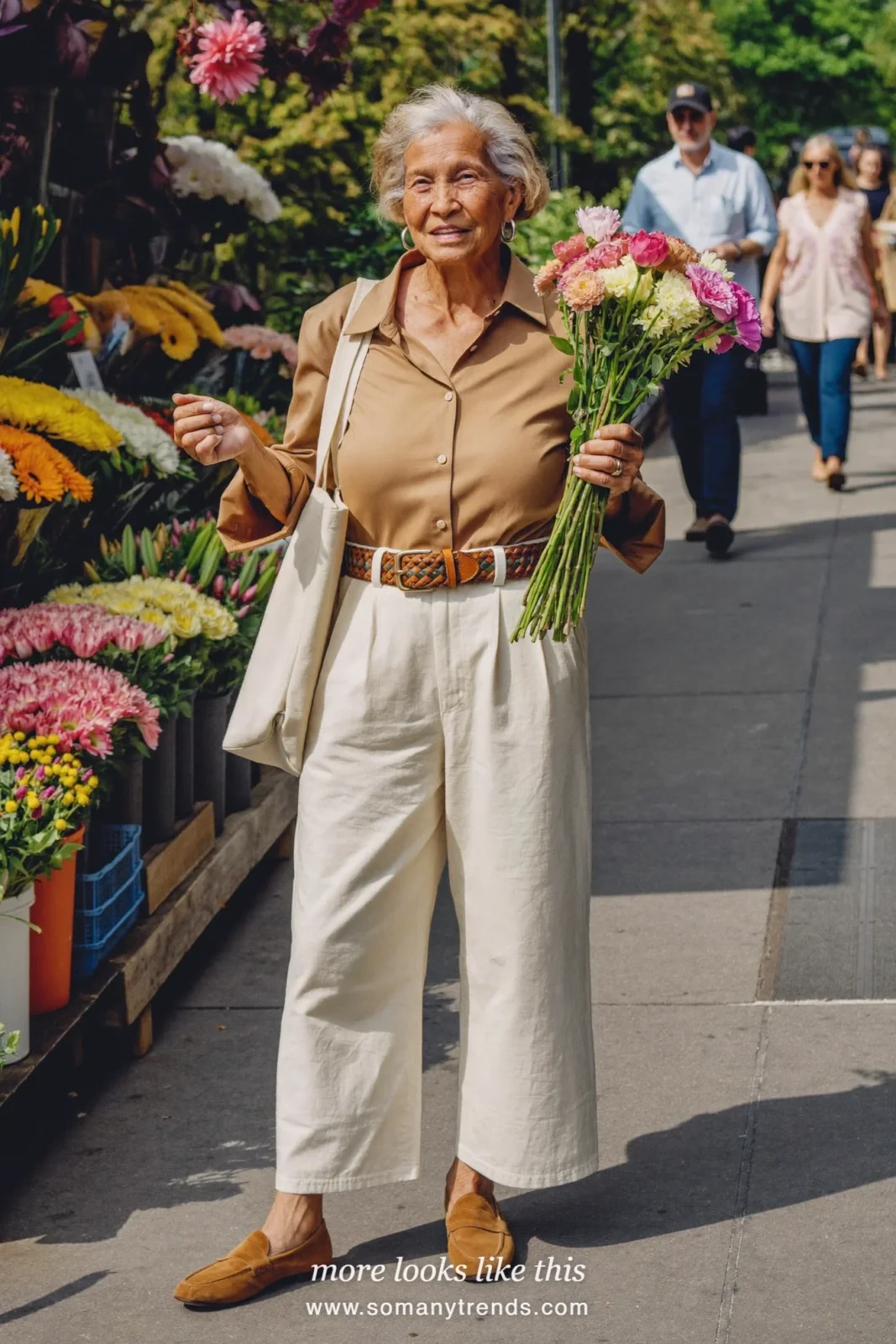 Woman in her seventies in a camel shirt, cream straight pants and tan suede loafers, look 11