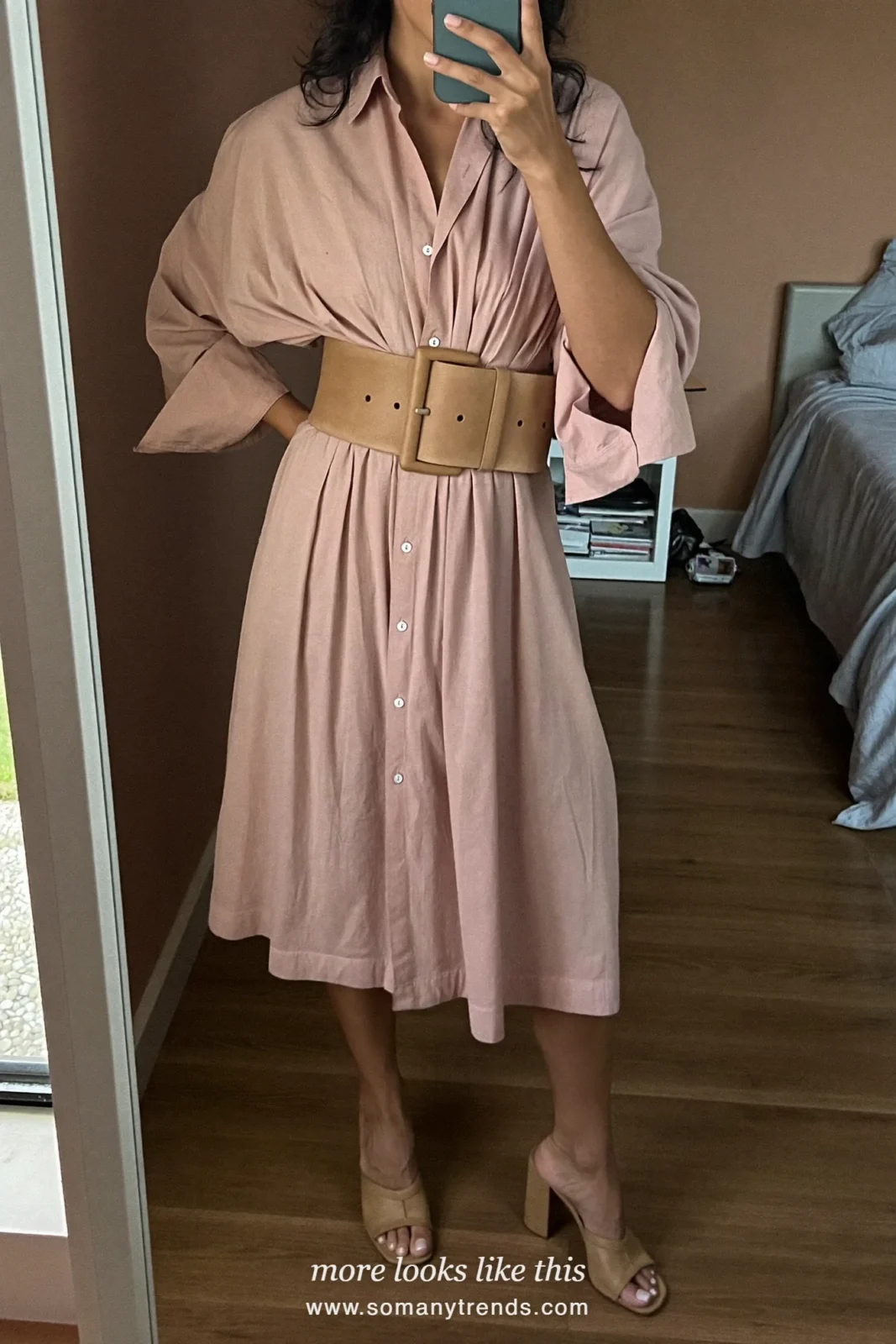 Woman in a blush shirt dress with a wide tan belt and block heels at a garden gate, wedding guest outfit 16