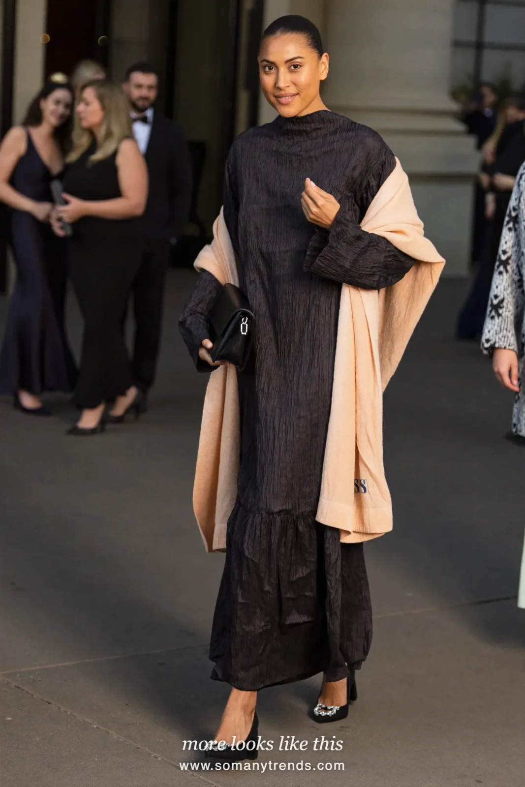 Woman in a black crepe maxi dress with a blush shawl and jeweled shoes at an evening wedding, wedding guest outfit 18