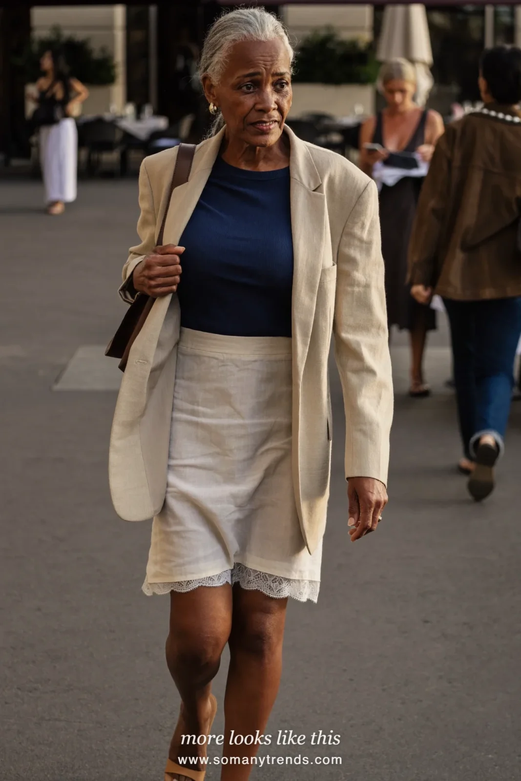 Woman in her forties wearing navy fine knit, cream lace-trim slip skirt, beige linen blazer and tan flat sandals, outfit 17