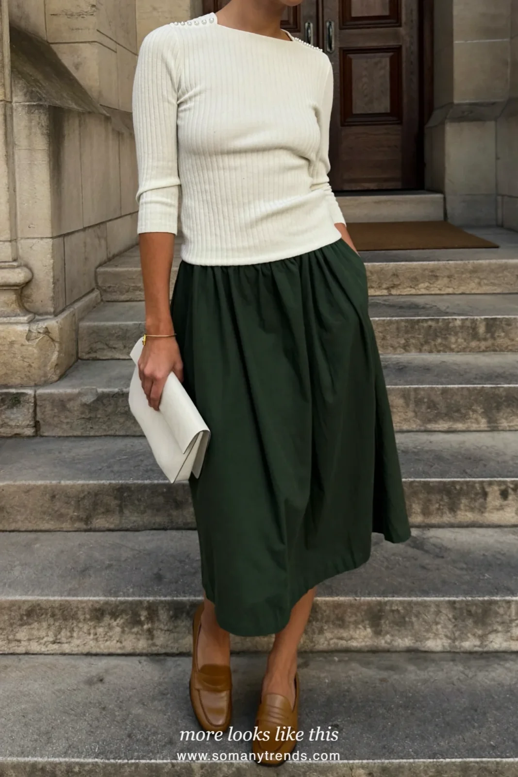 Woman in a forest green midi skirt, ivory fine knit with pearl buttons and tan loafers, Easter outfit 6
