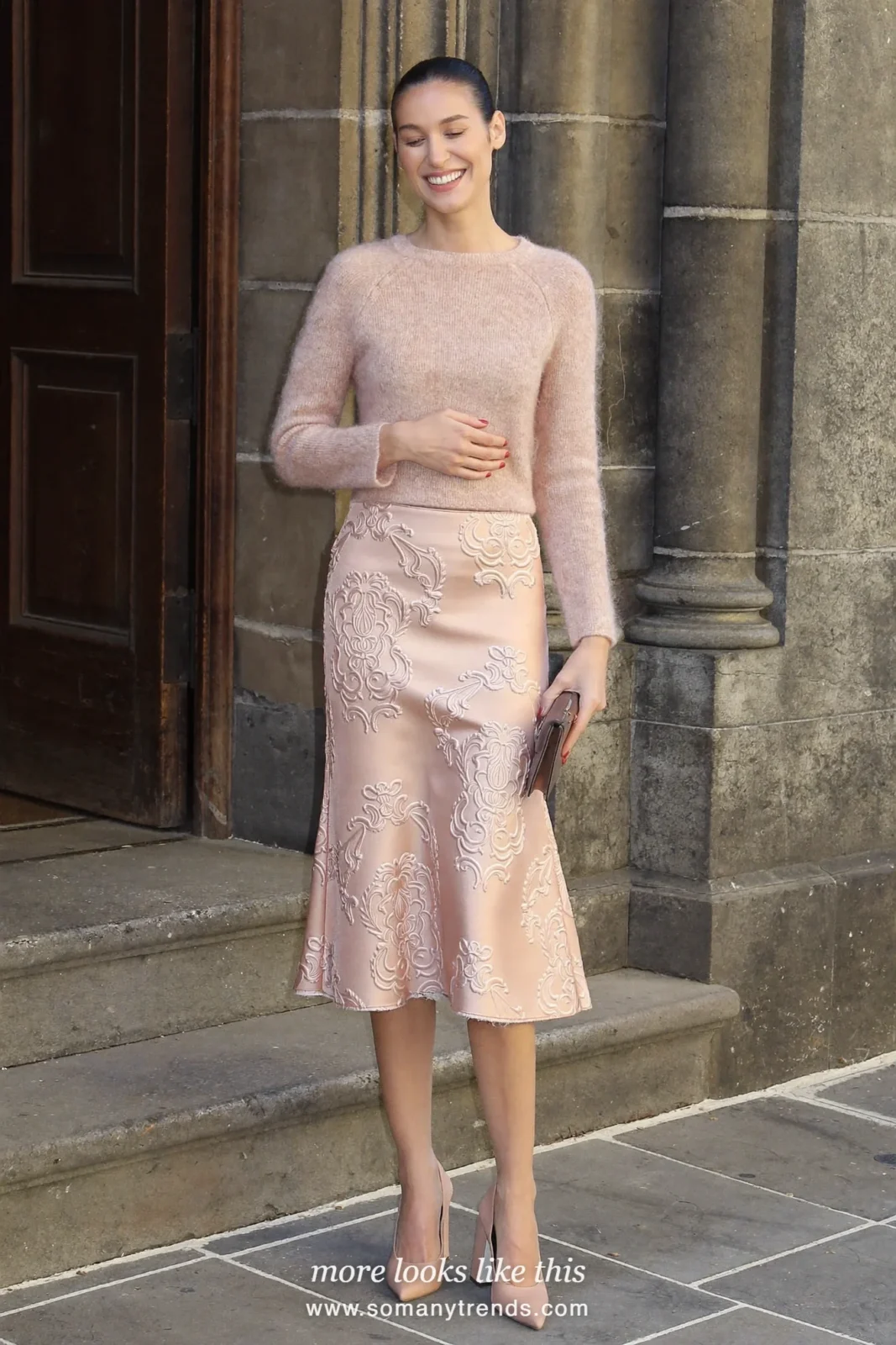 Woman in a blush brocade midi skirt, fine blush knit top and block-heel pumps with bare legs, wedding guest outfit 1