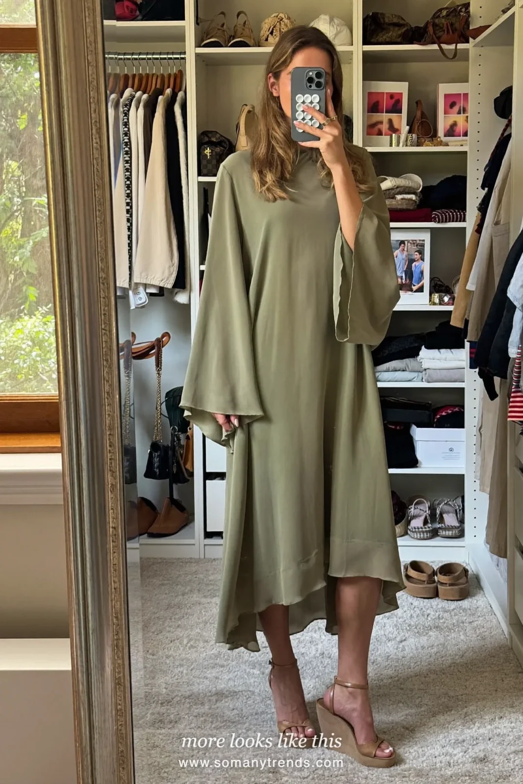 Woman in a sage green chiffon midi dress with flowing sleeves and wedges on a garden path, wedding guest outfit 24
