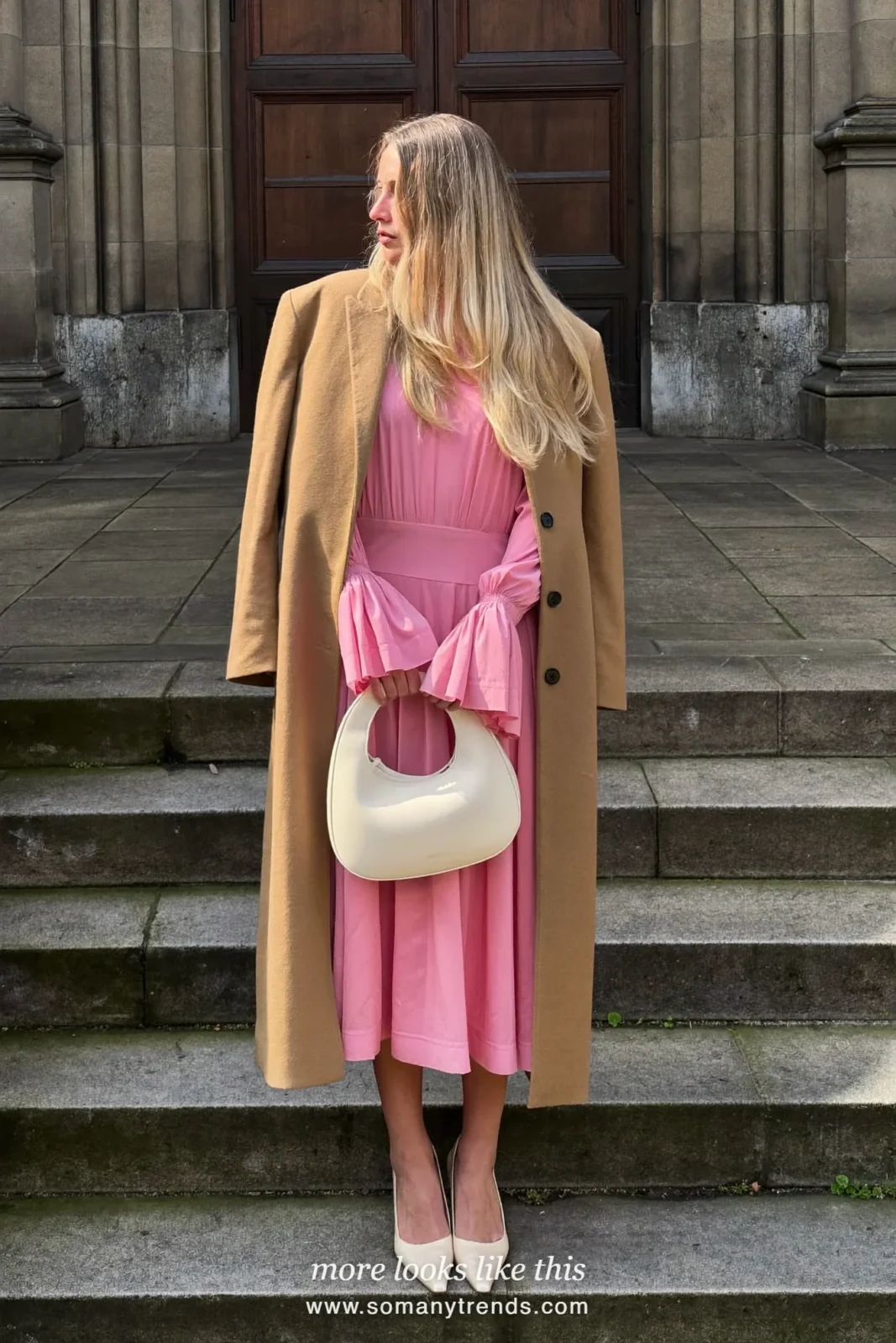 Woman in a long camel coat open over a candy pink sleeved midi dress with cream pumps, Easter church outfit 26