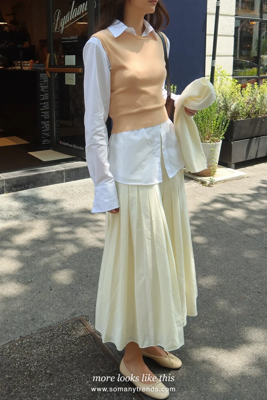 Woman in a peach knit vest, white shirt, ivory pleated midi skirt and ballet flats, Easter outfit 11