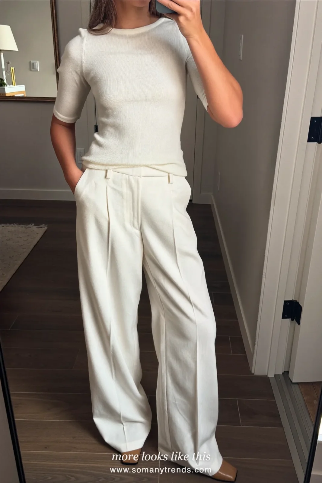 Woman in a belted camel wool coat, cream knit, ivory straight pants and tan square-toe pumps, outfit 12 mirror selfie