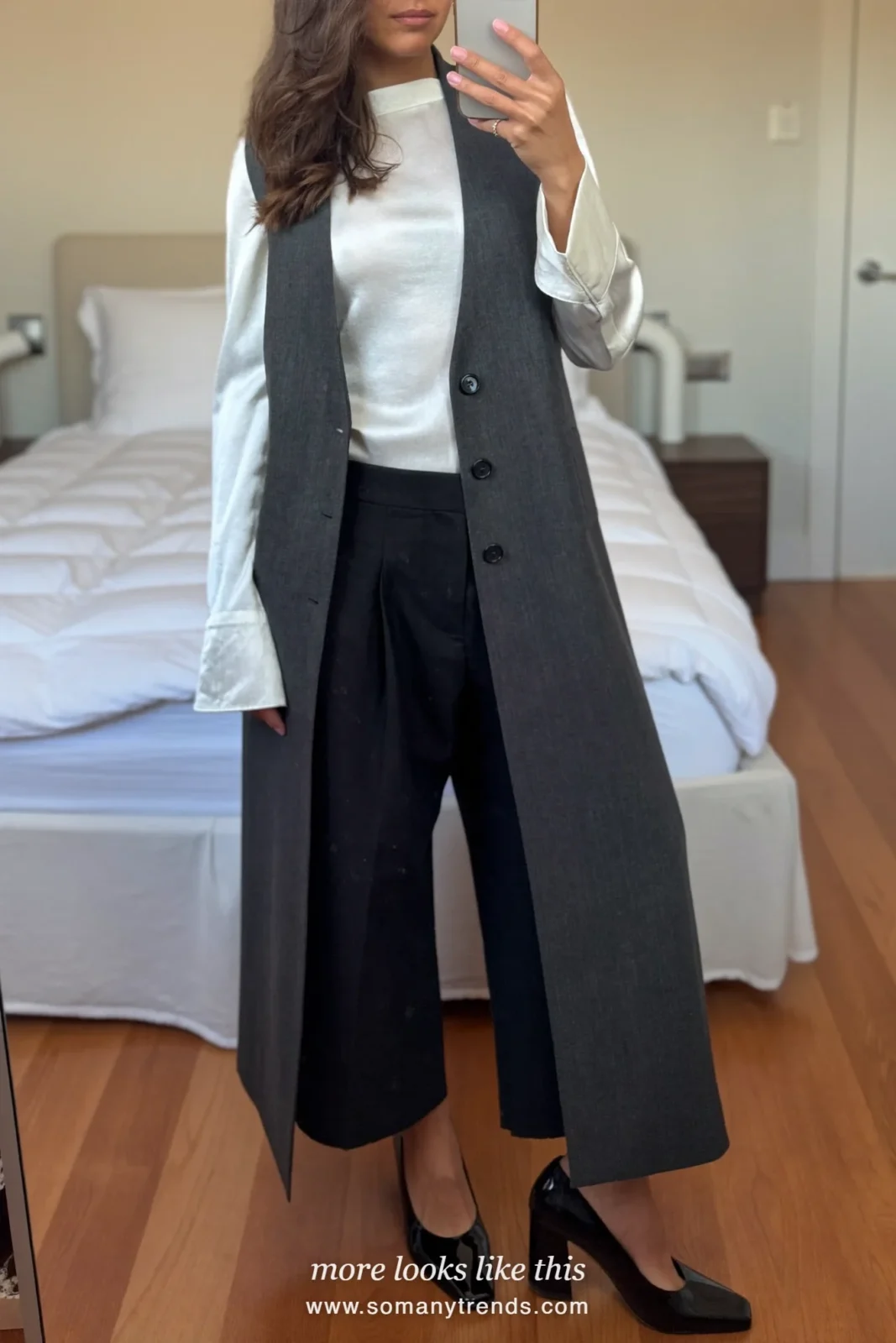 Woman in a long charcoal vest, white blouse, black straight pants and block-heel pumps at a keynote, work conference outfit 8