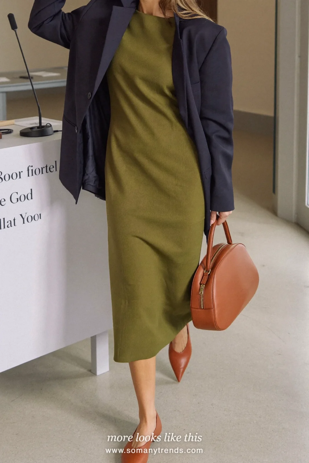 Woman in an olive column midi dress, navy oversized blazer and cognac pointed flats at a conference, work conference outfit 9