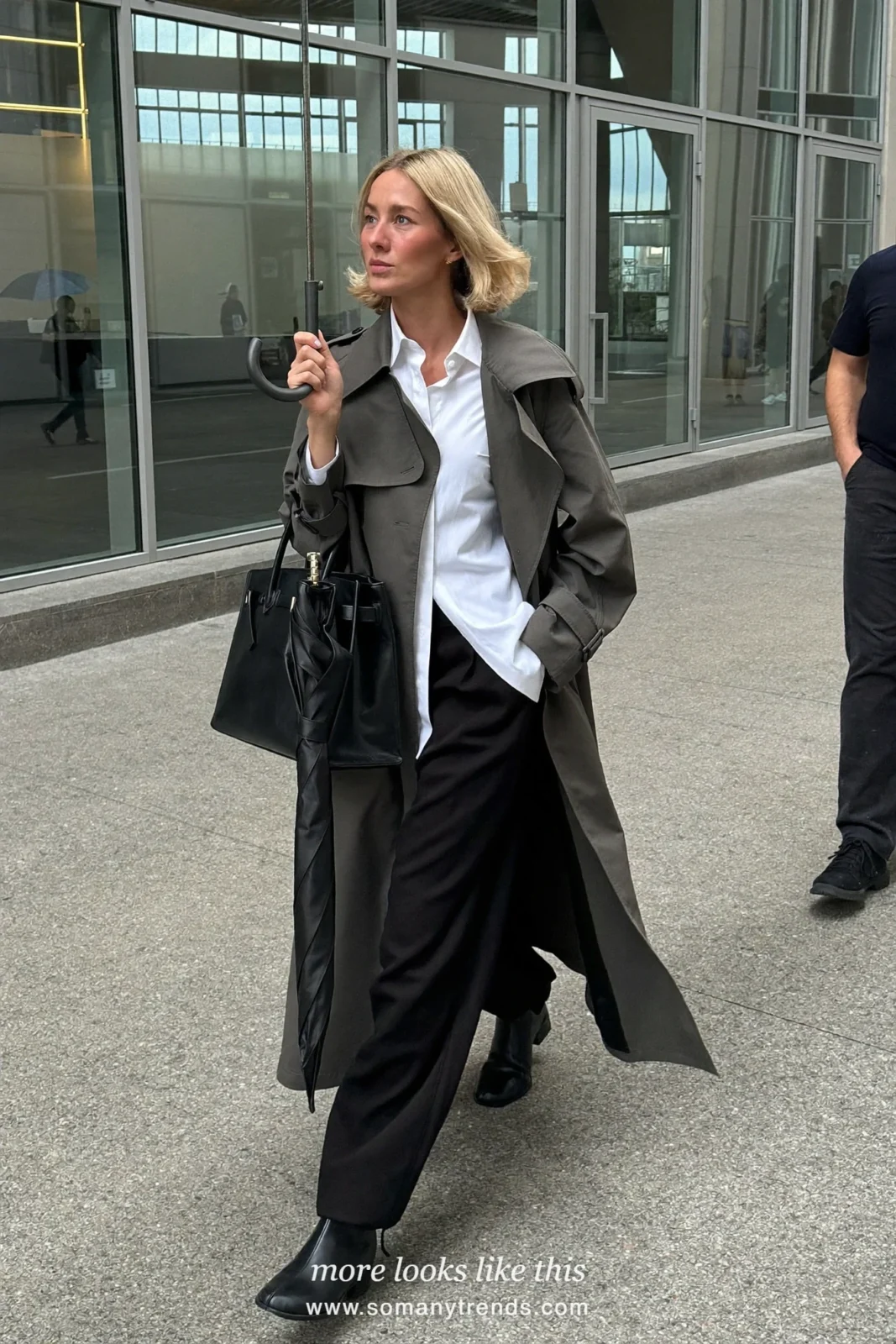 Woman in a charcoal trench coat, white shirt, black straight pants and ankle boots outside a conference venue, work conference outfit 18