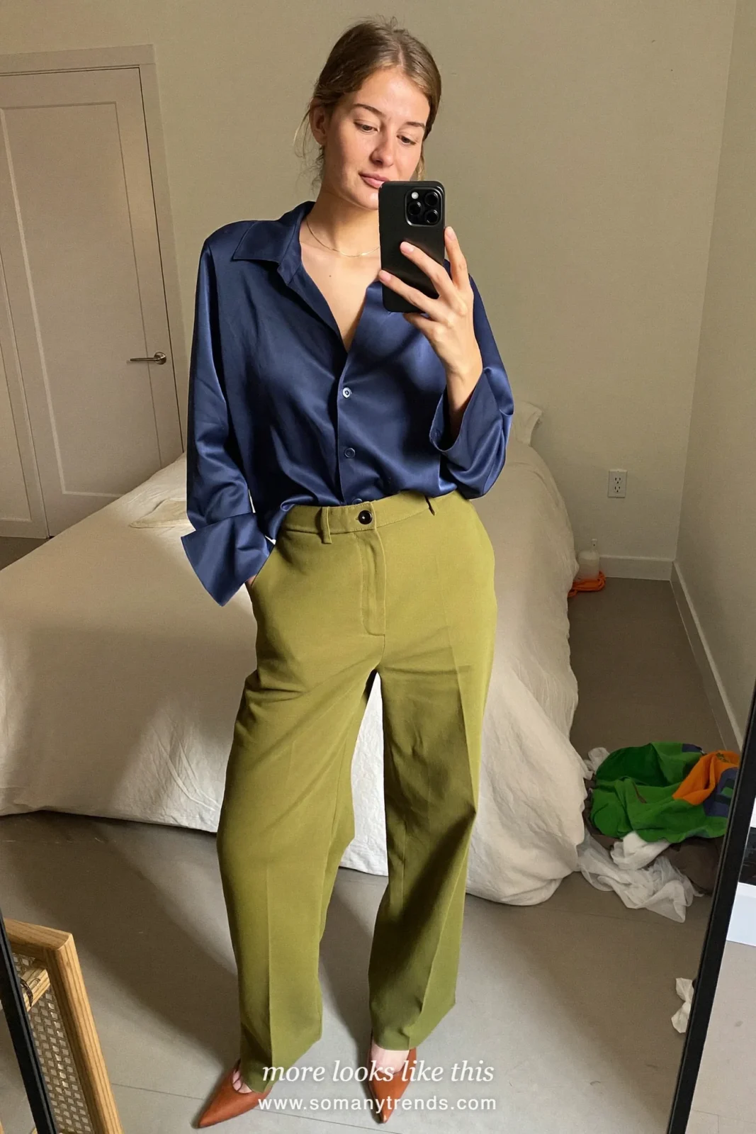 Woman in olive wide-leg pants, a navy blouse and pointed pumps at a reception, work conference outfit 20