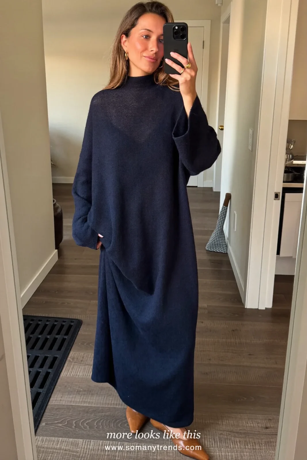 Woman taking a mirror selfie in a hotel hallway in a navy knit maxi dress and cognac flats, work conference outfit 24