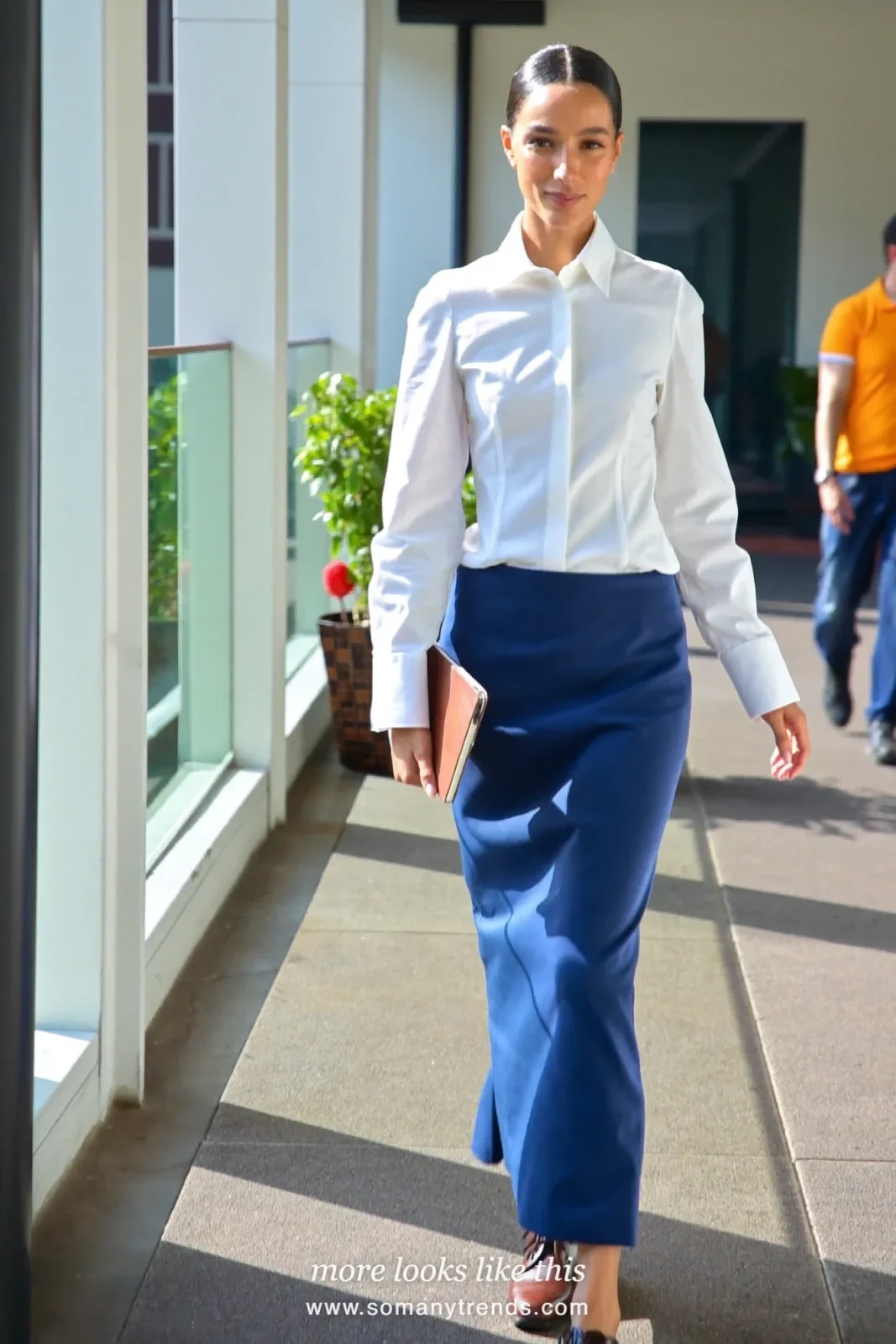 Woman in an ivory crisp shirt, ink blue ankle-length column skirt and brown leather derby shoes, first day at work outfit 8